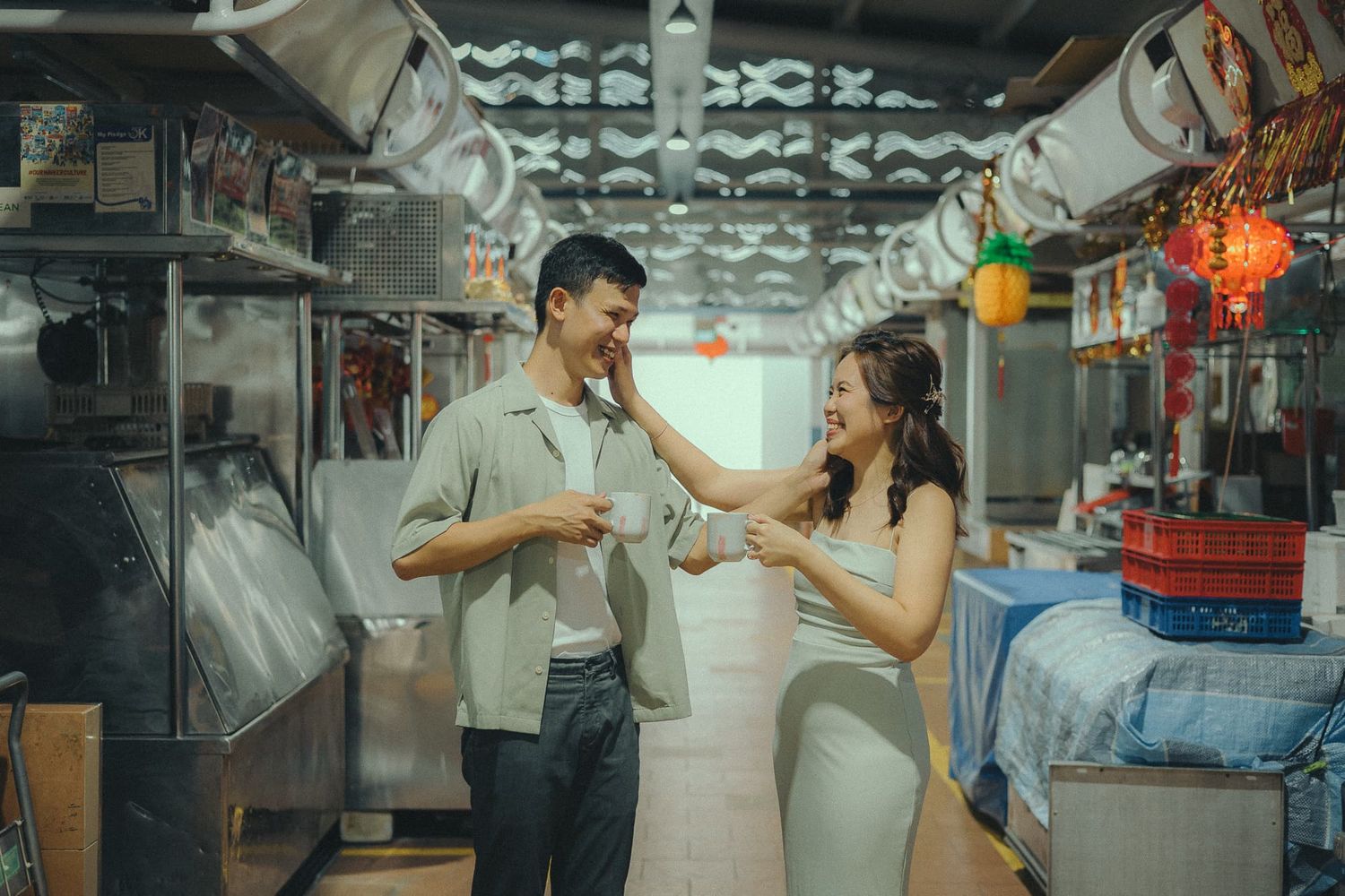 Couple sharing a playful moment in an illuminated market stall.