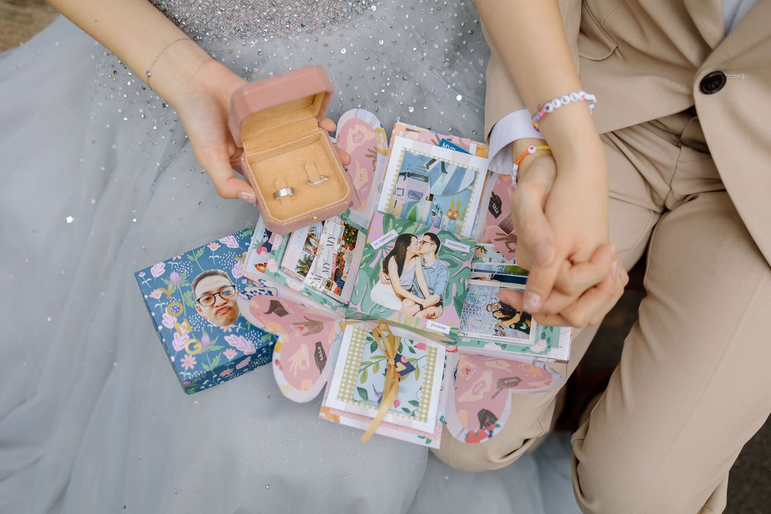 Close-up of hands holding colorful anime-themed cards against a tulle dress.
