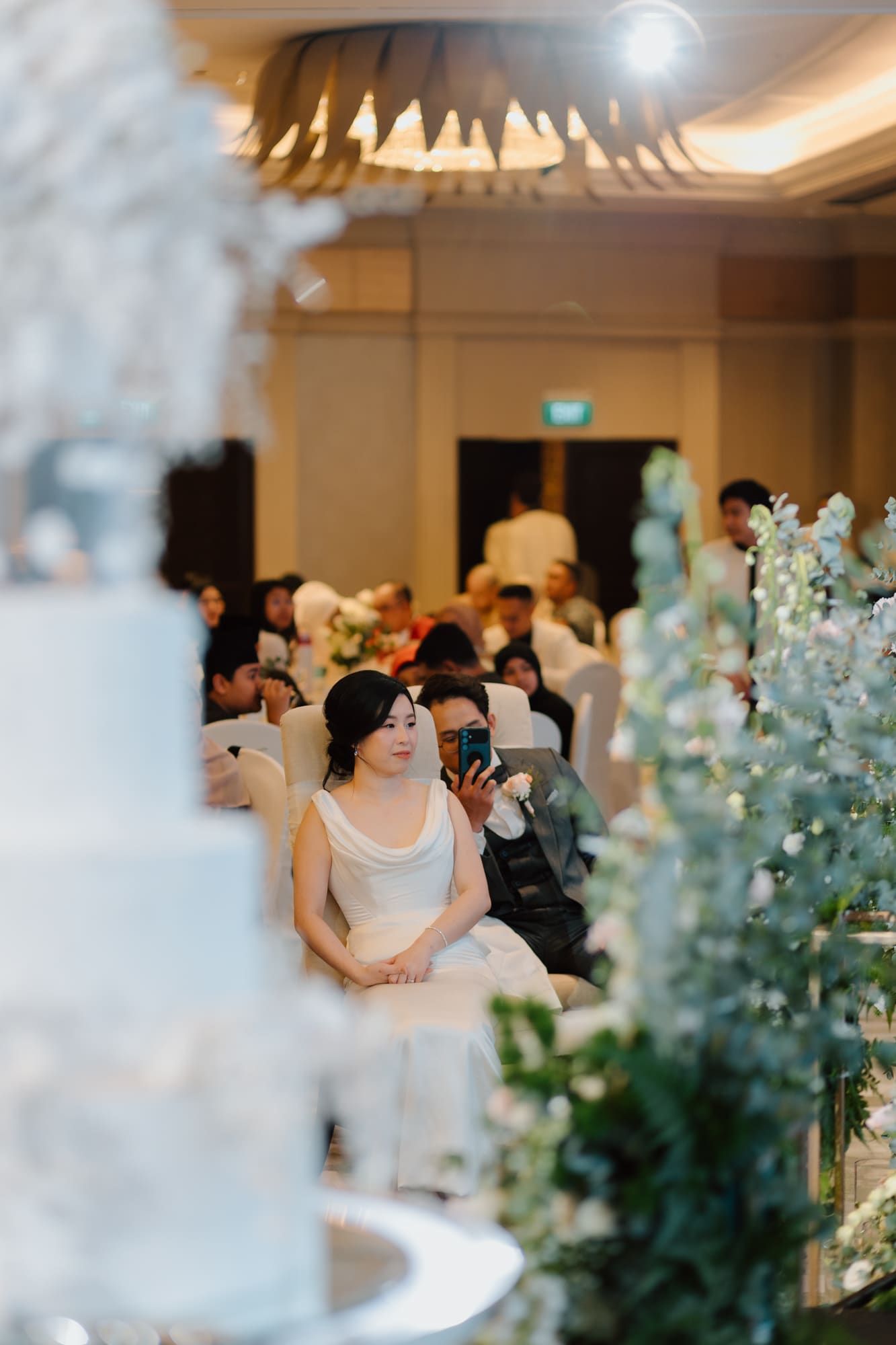 Elegant wedding reception scene with soft lighting and eucalyptus decorations creating a romantic atmosphere.