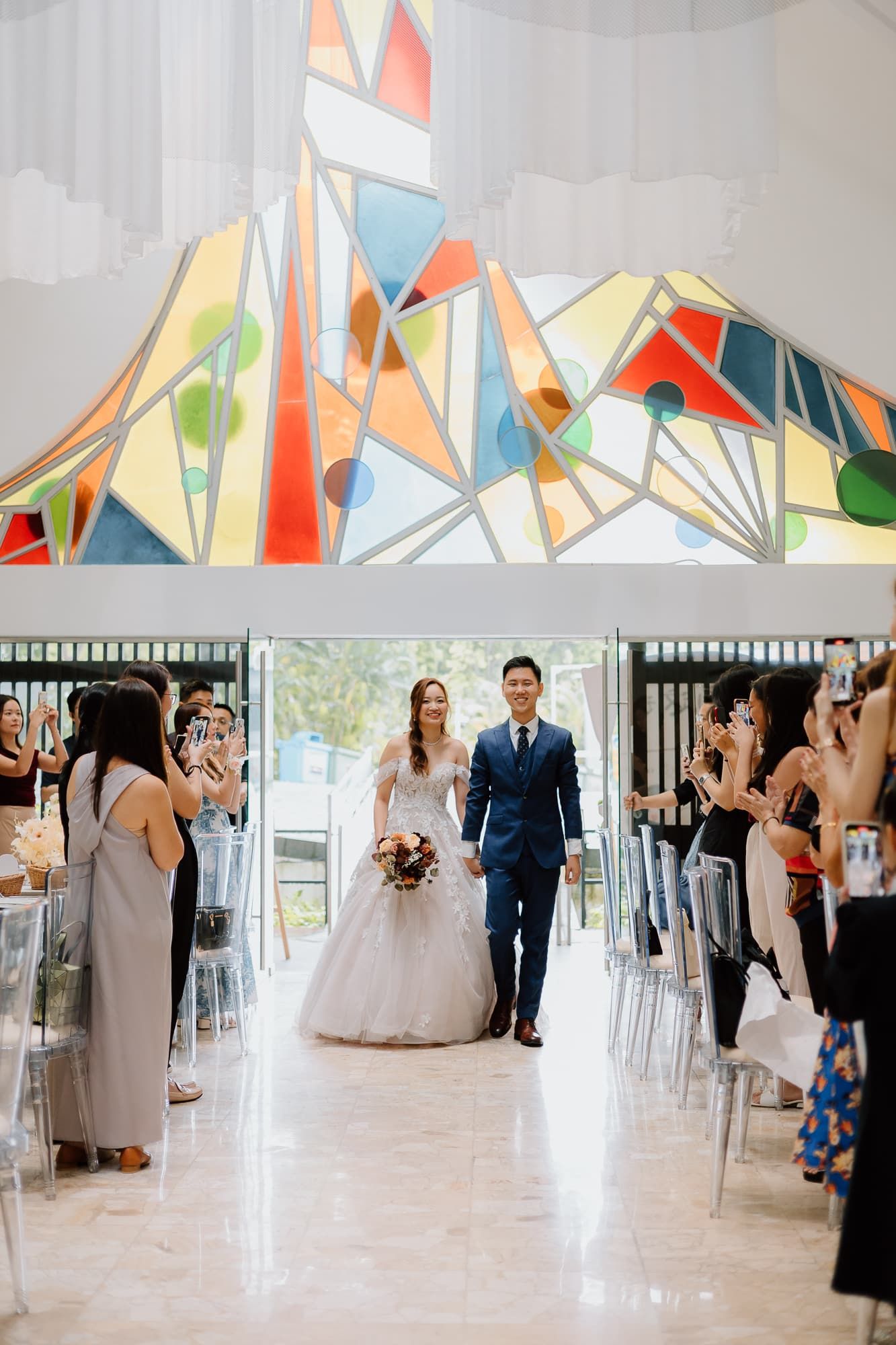 Wedding reception hall decorated with colorful geometric decorations and a bright white interior.