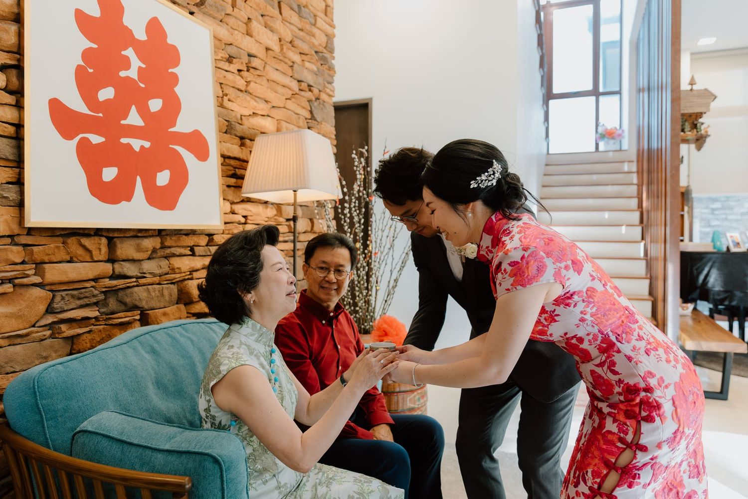 Wedding guests gather around a table during a traditional Chinese tea ceremony celebration.