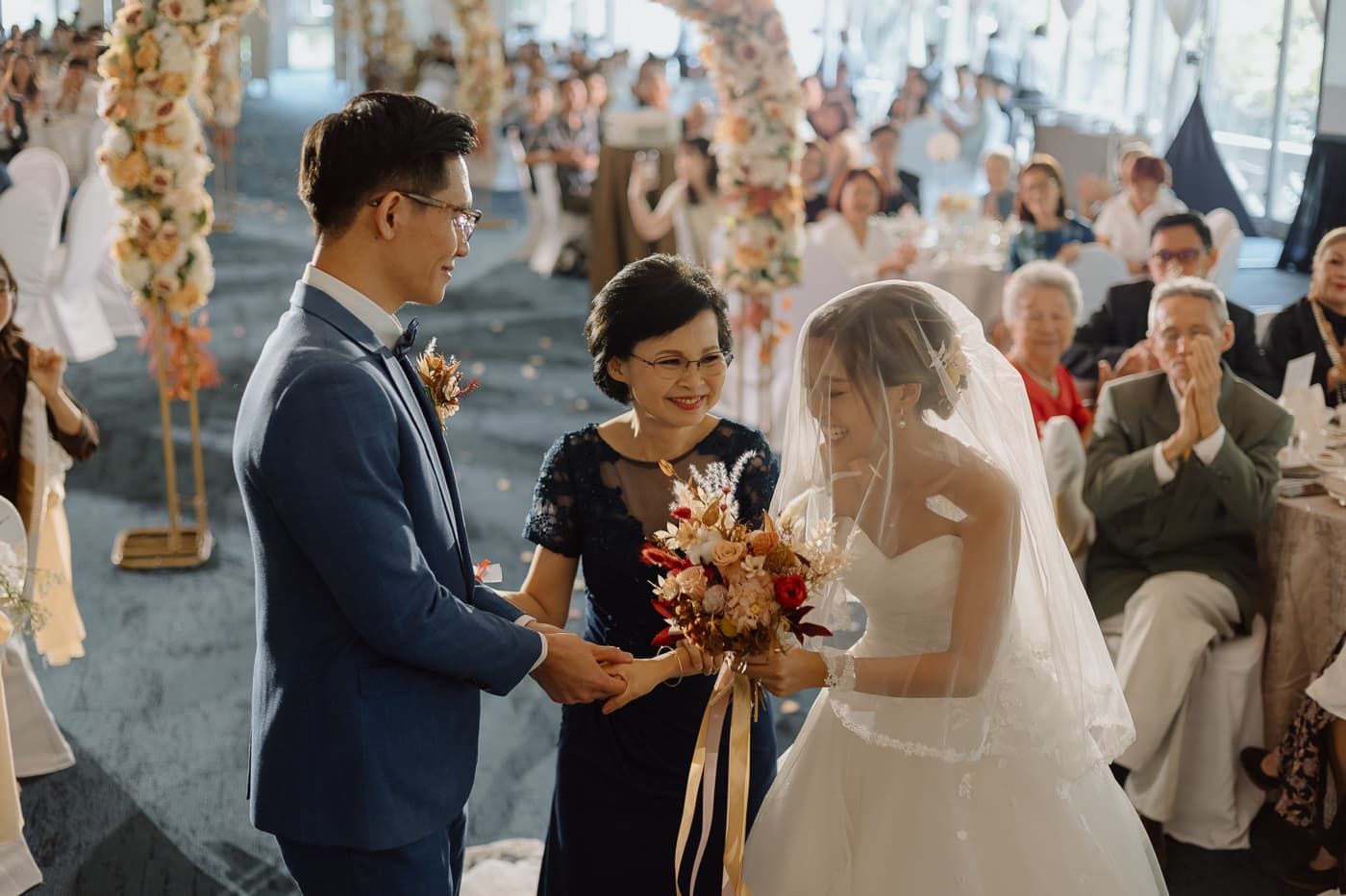 Traditional wedding ceremony moment captured under romantic floral arch decorations.
