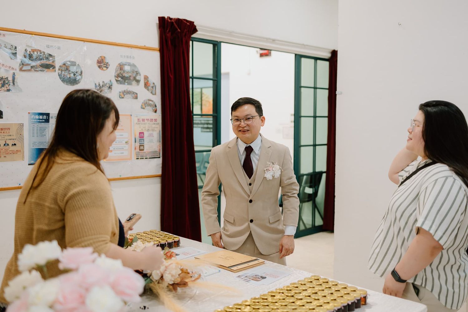 A meeting space decorated with floral arrangements and display photos.