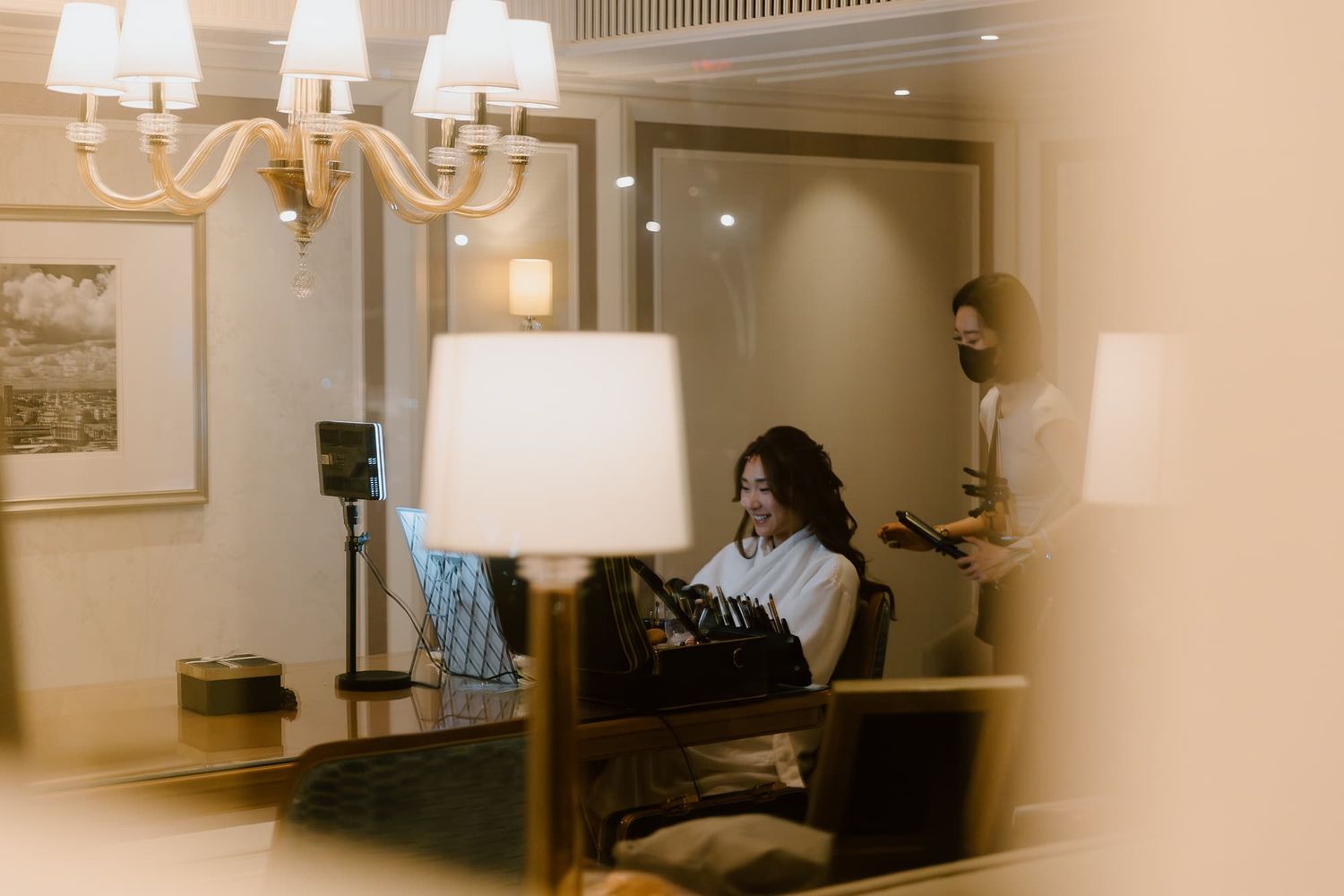 Candid shot through window showing interior of elegant room with chandelier and furniture.