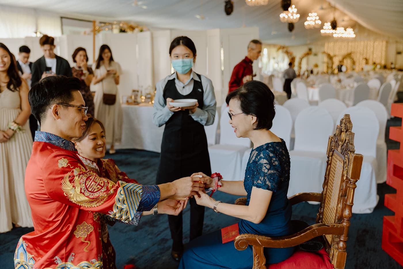 Traditional Chinese tea ceremony taking place in an elegantly decorated banquet room.