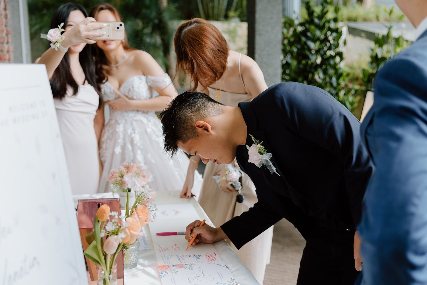 Wedding guests signing the guest book at an elegant reception.