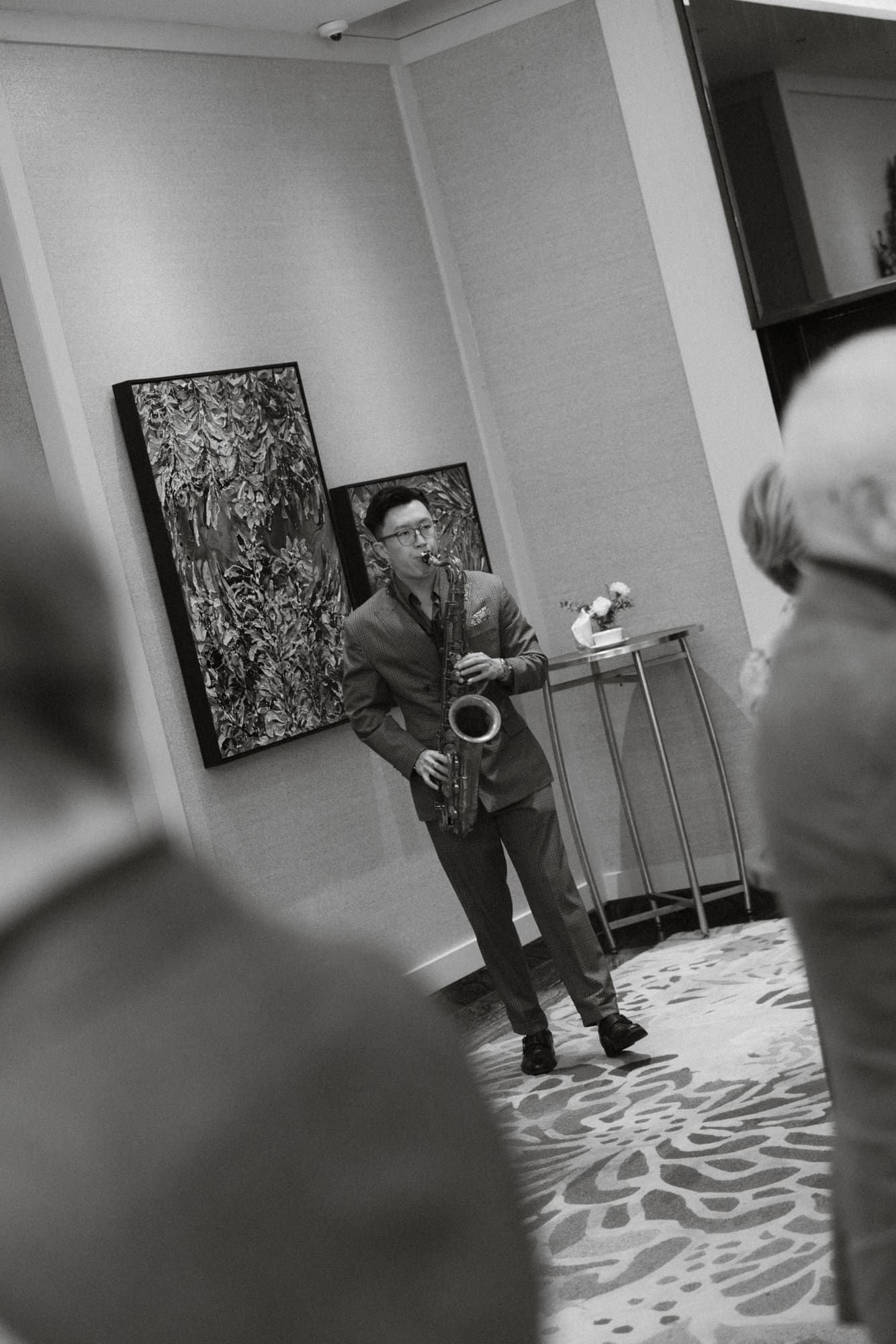 Black and white photos showing someone performing dance moves in an art gallery with abstract paintings on walls.
