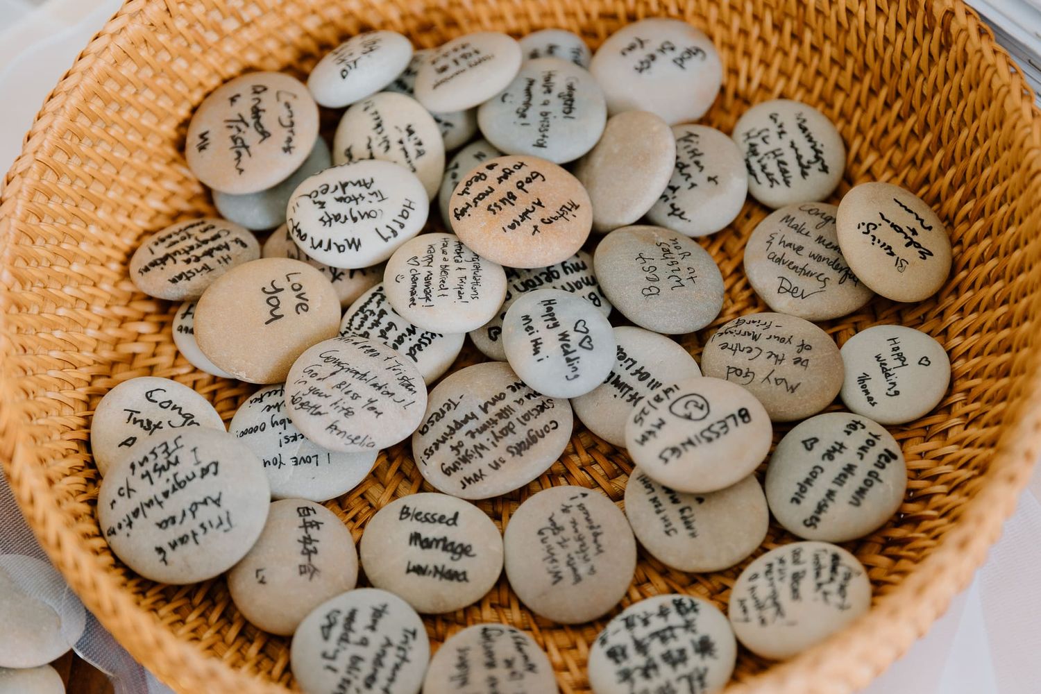 A woven basket filled with small round buttons or pins with text written on them.