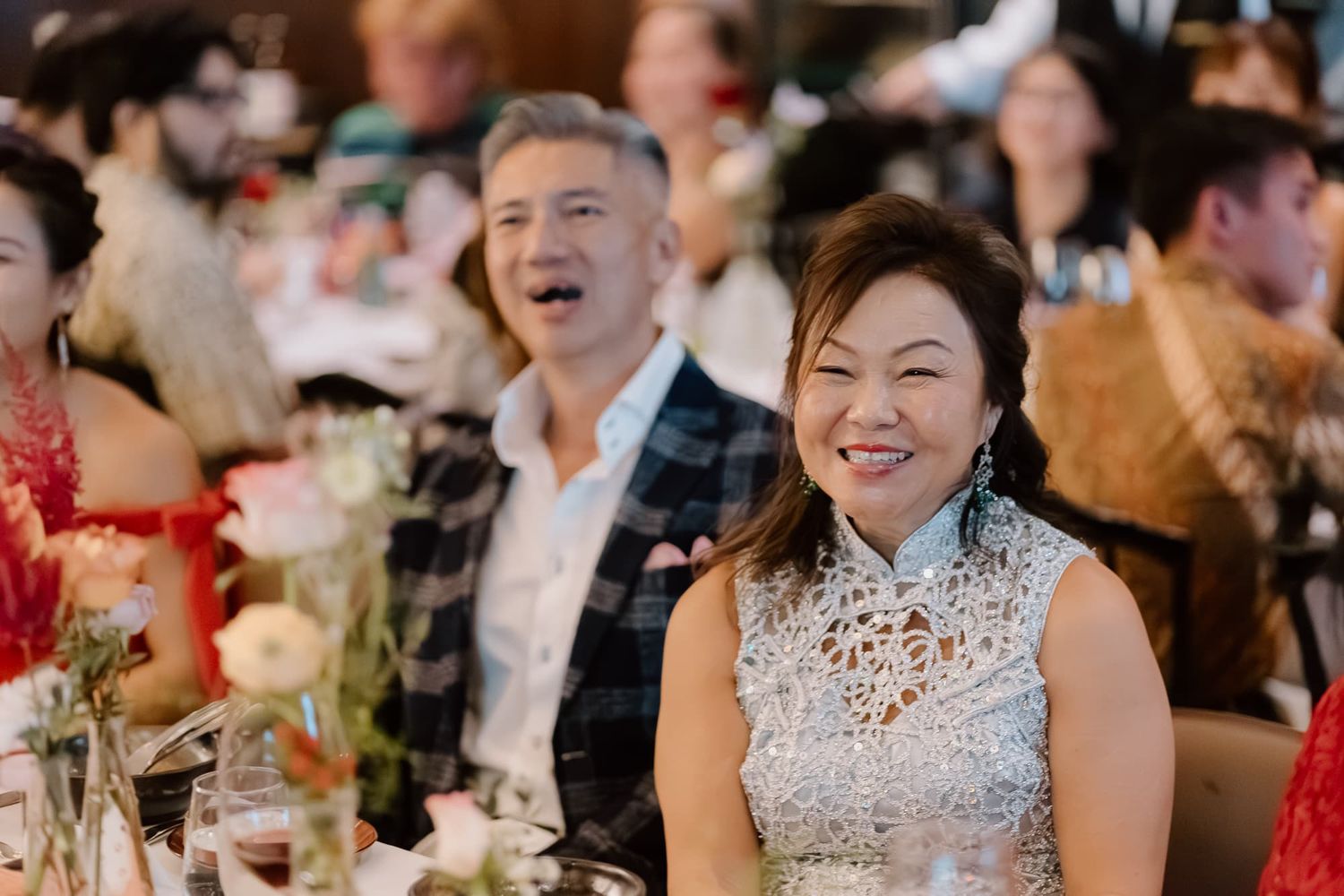 Wedding guests enjoying dinner reception at elegantly decorated tables.