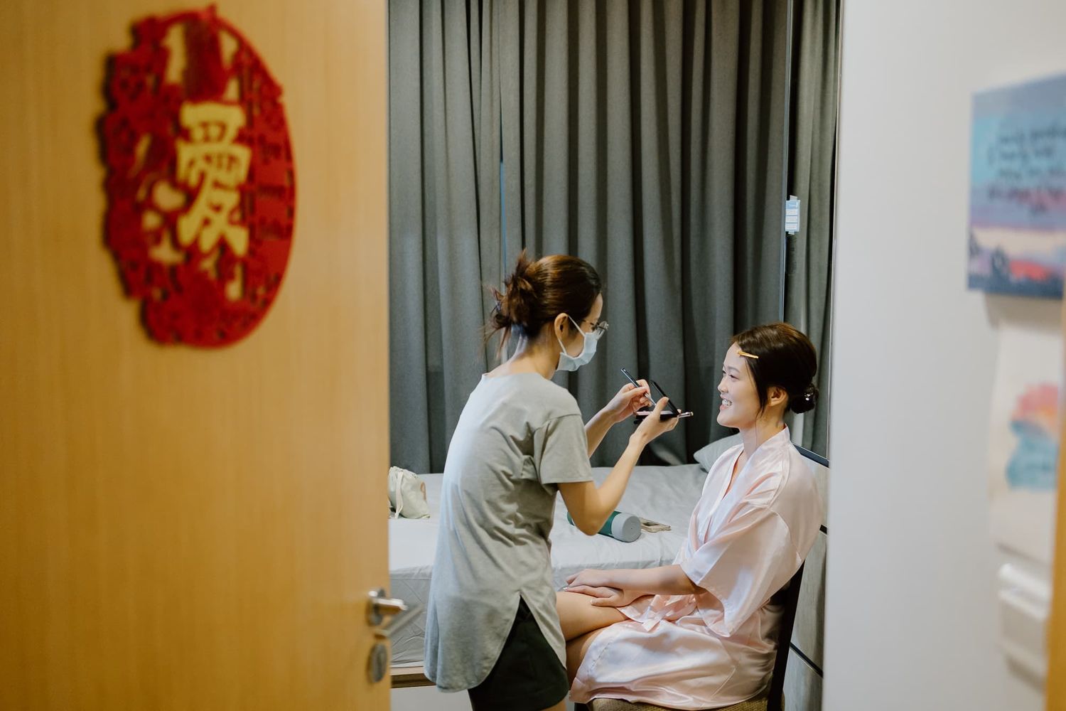 Makeup artist applying cosmetics in a room with traditional Chinese decor.