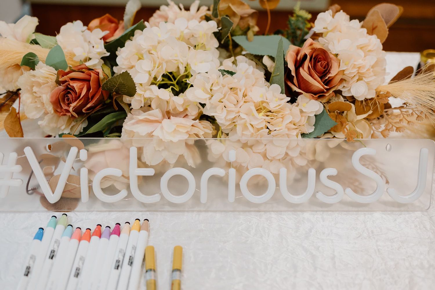 Delicate pink and peach floral arrangements with white lettering decor.