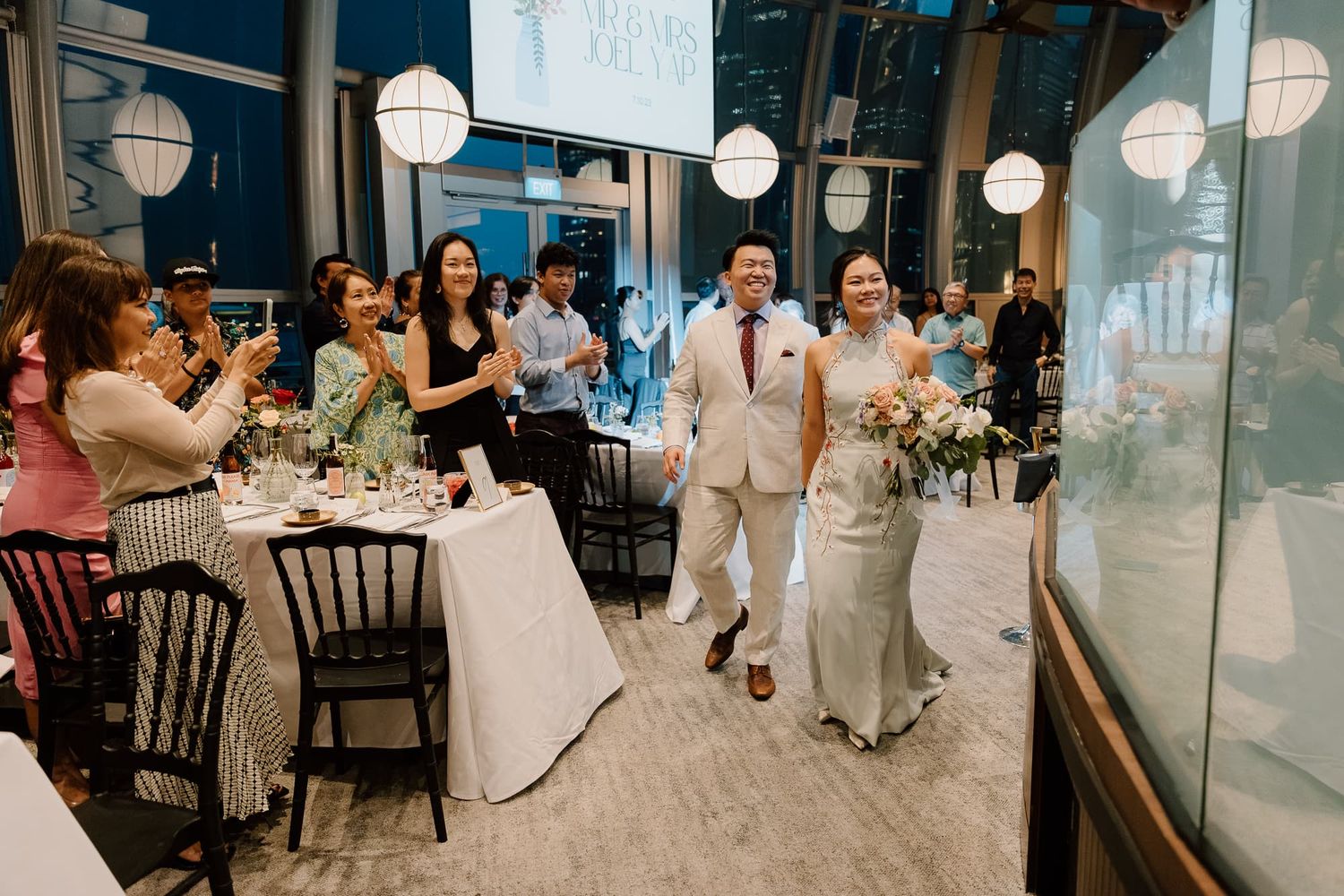 Wedding celebration in an indoor venue decorated with hanging paper lanterns.