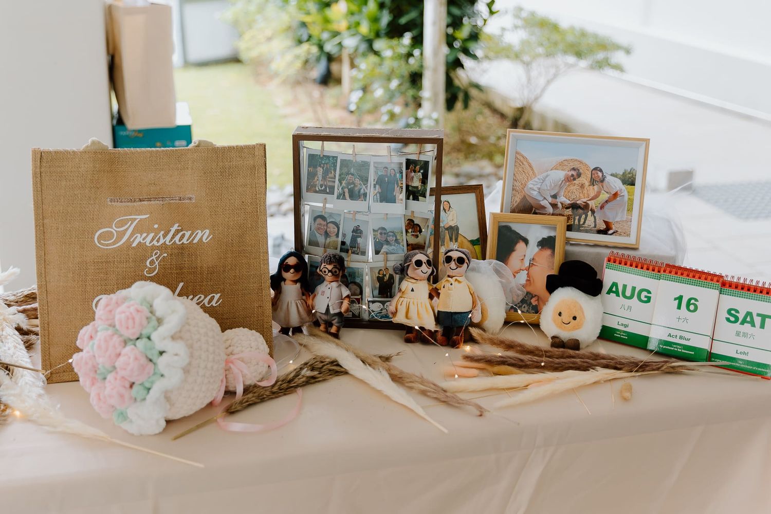 Wedding reception decor features photo displays, a guestbook, and vintage decor elements arranged on a white tablecloth.