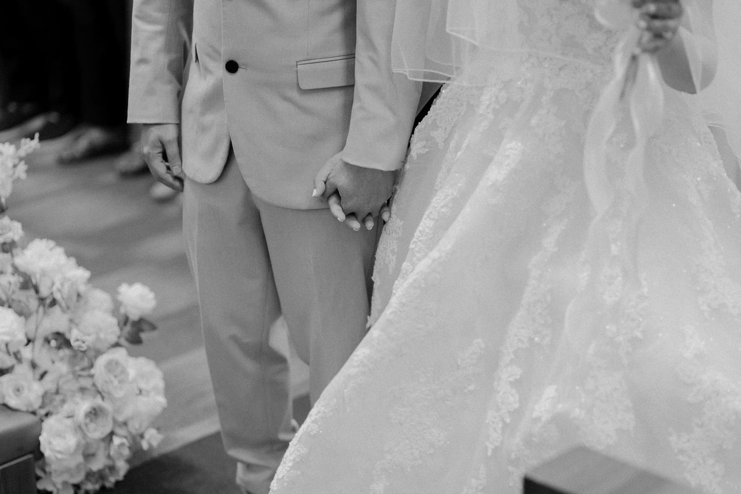 A black and white detail shot of a bride and groom's formal wedding attire.