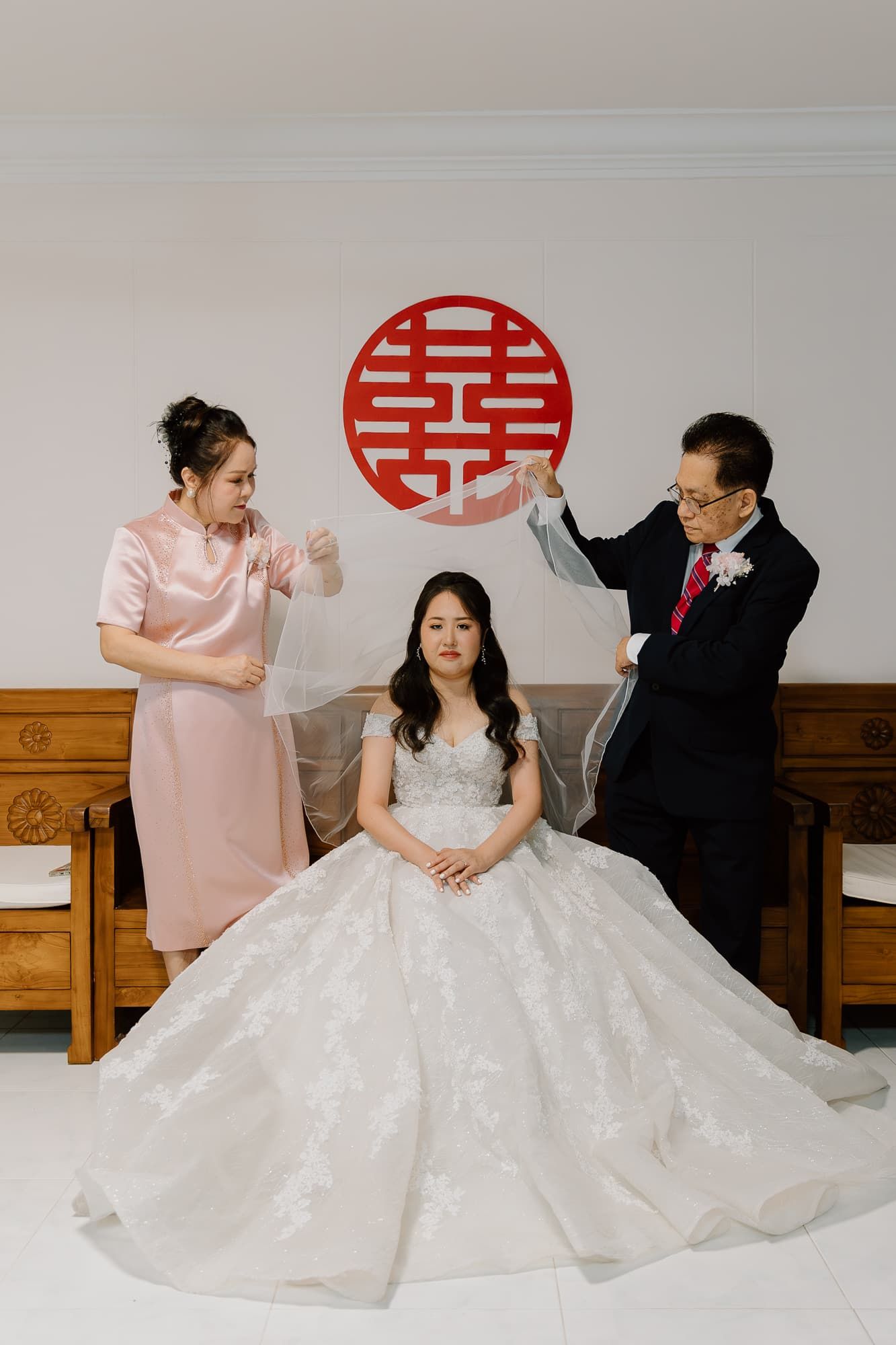 Wedding scene with traditional Chinese double happiness symbol and elegant white gown.