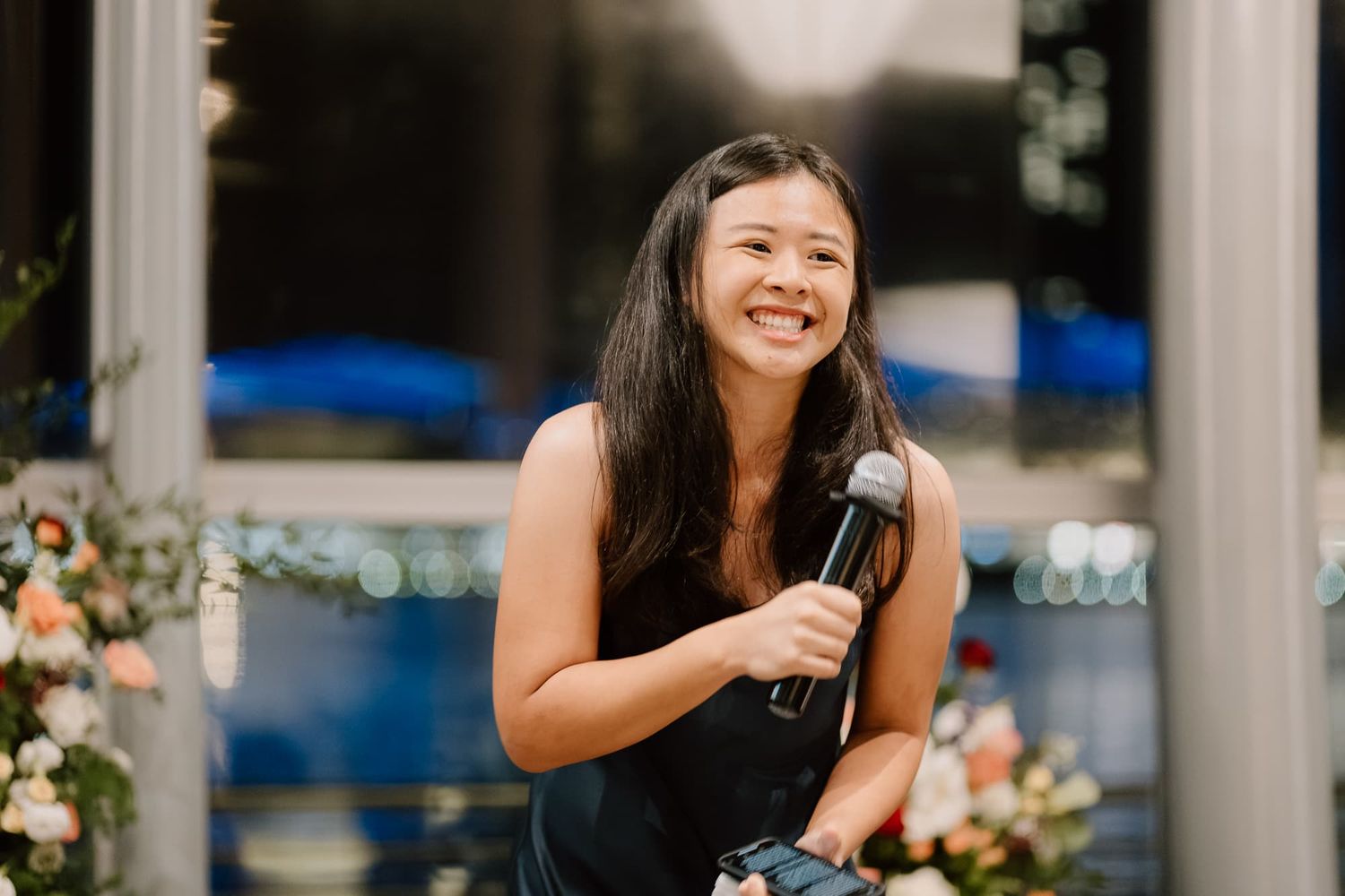 Guest gives emotional speech at wedding reception with floral decorations.