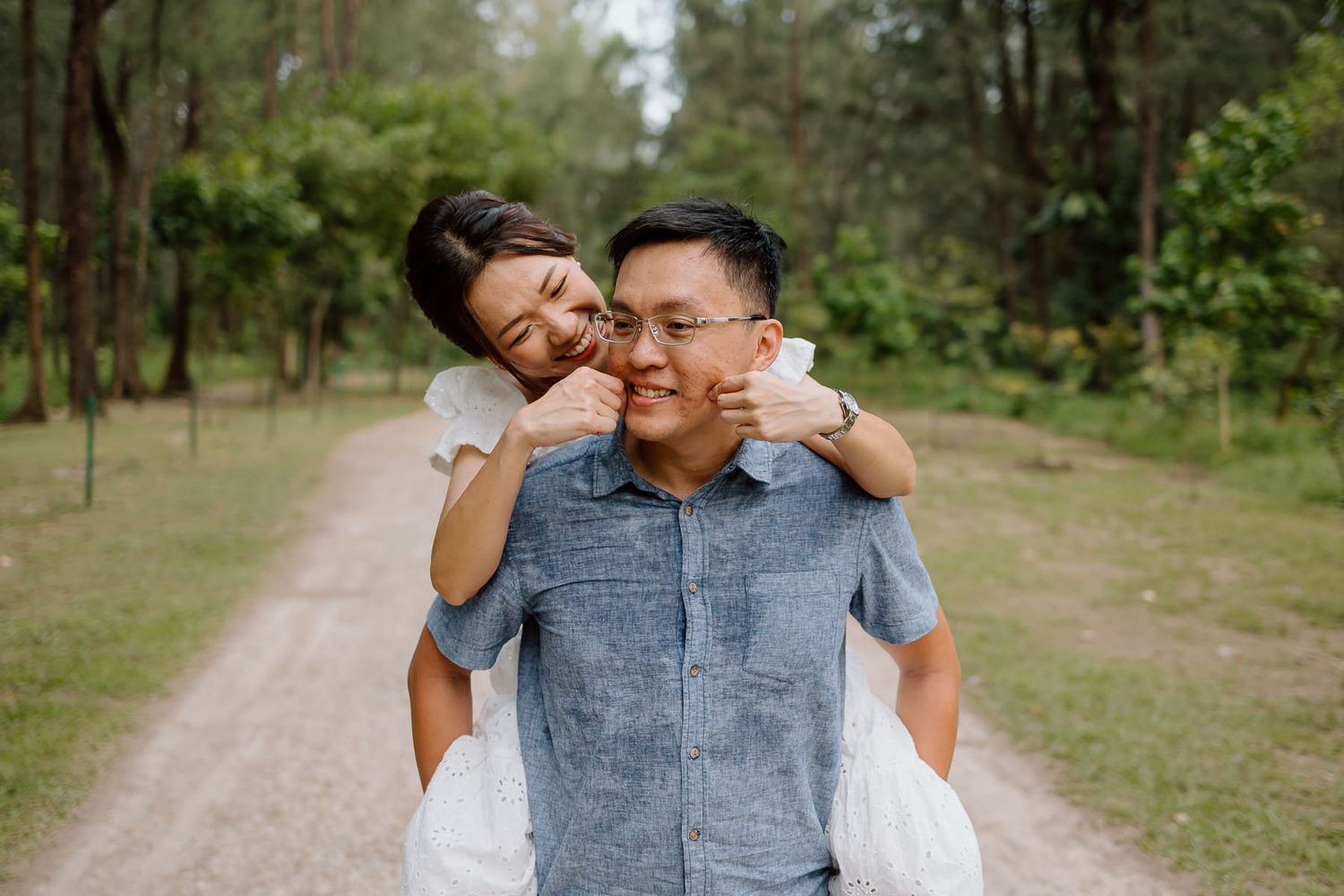 Joyful piggyback ride moment captured in a natural forest setting.