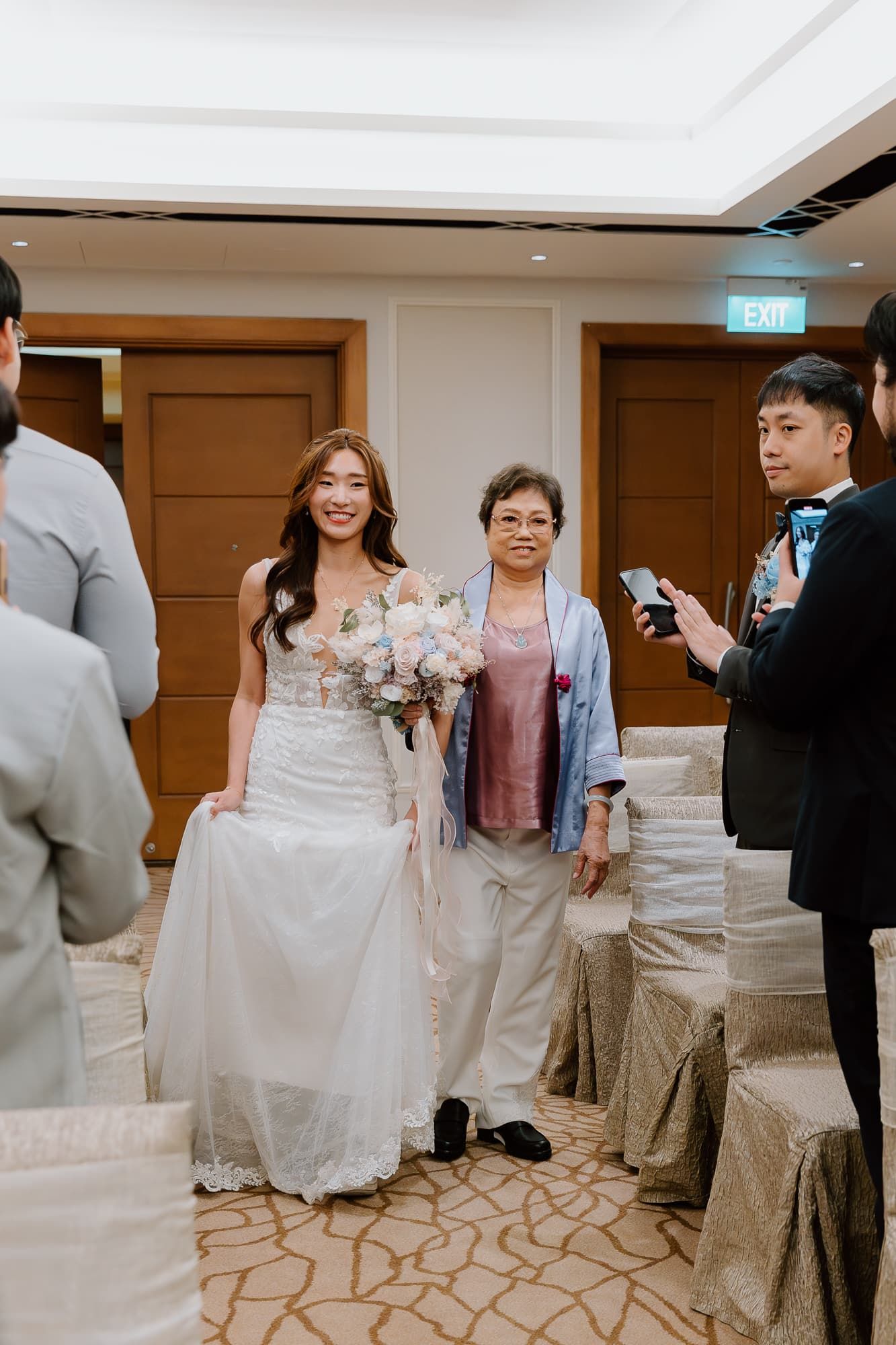 Wedding ceremony venue with cream-colored chair covers and elegant carpet pattern.