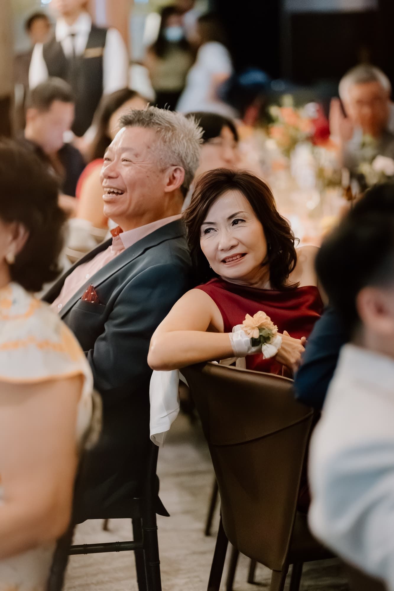 Wedding guests smile and enjoy themselves during an elegant reception dinner.