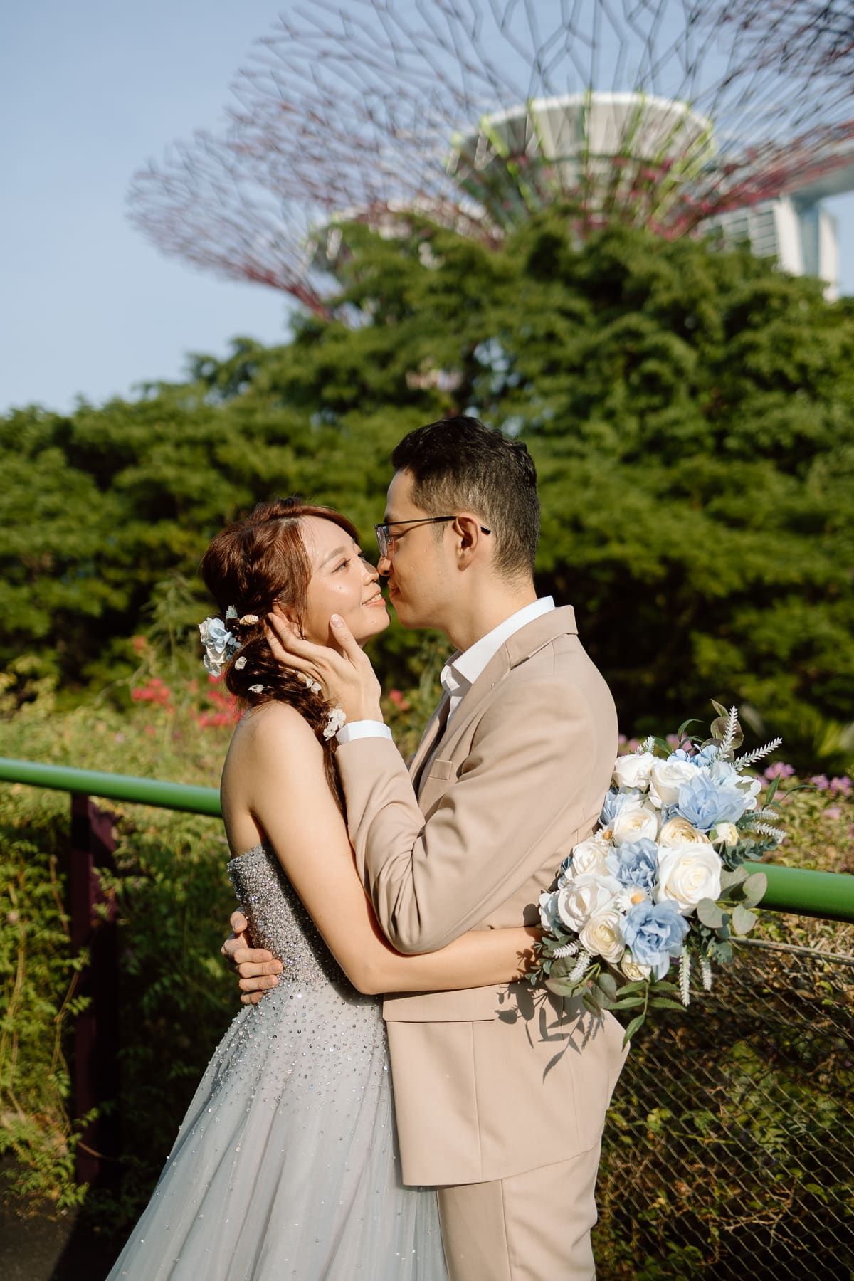 An intimate wedding portrait with Singapore's iconic Supertree Grove visible in the background.