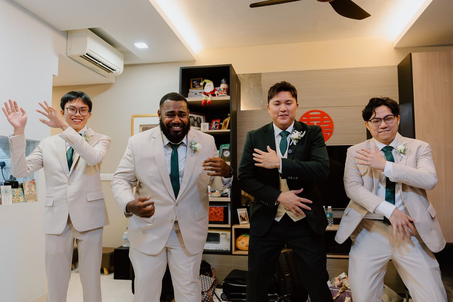Groomsmen in white suits celebrating and posing together in an indoor venue.