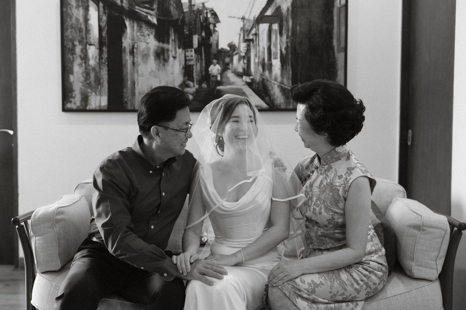 Black and white photo showing a group of people sitting together in a casual indoor setting.