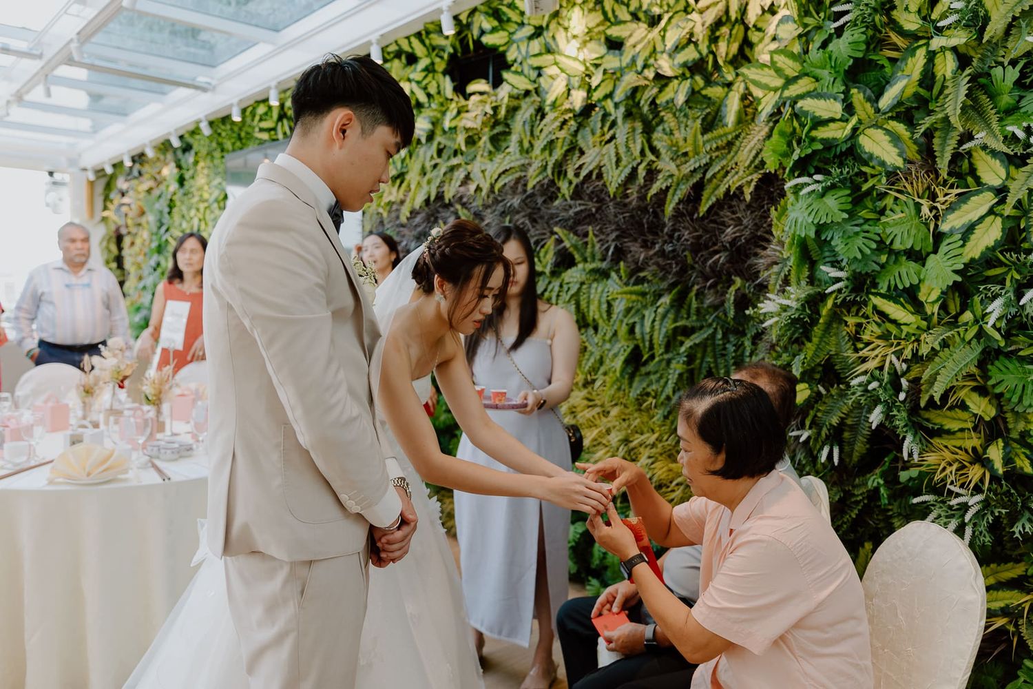 Wedding ceremony guests seated in outdoor garden setting.