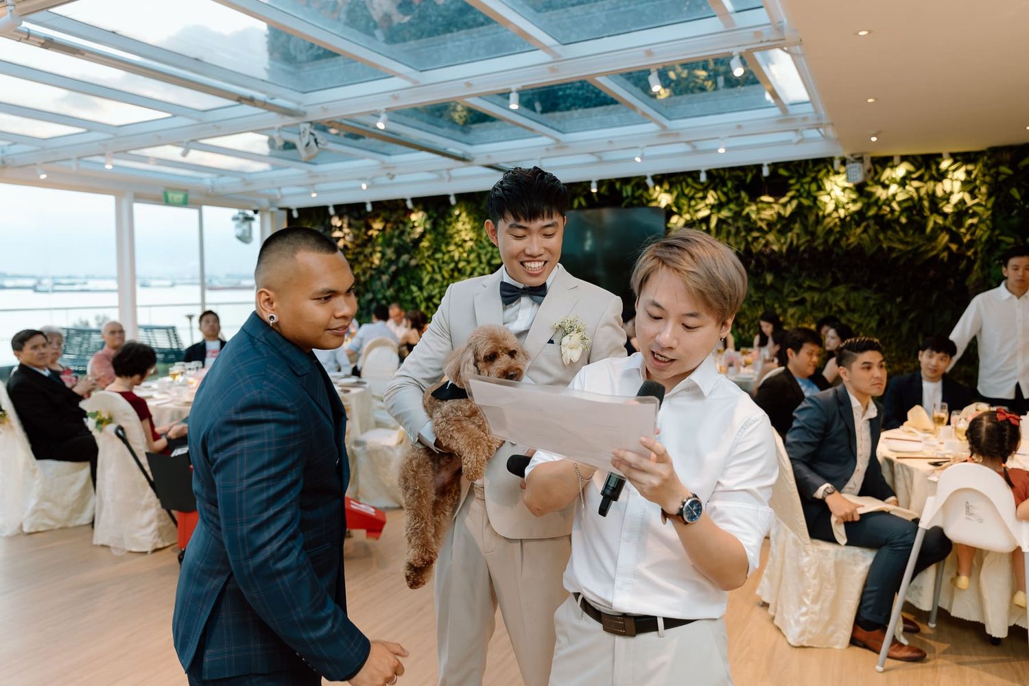 Wedding guests enjoy an elegant reception celebration in a bright indoor venue with white decor.