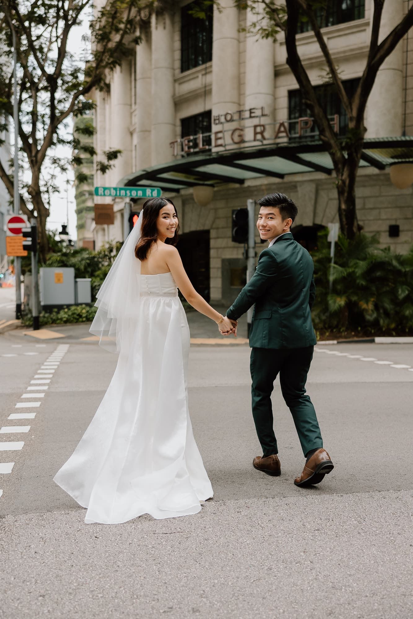 Playful wedding photoshoot sequence showing the couple dancing on a city street.