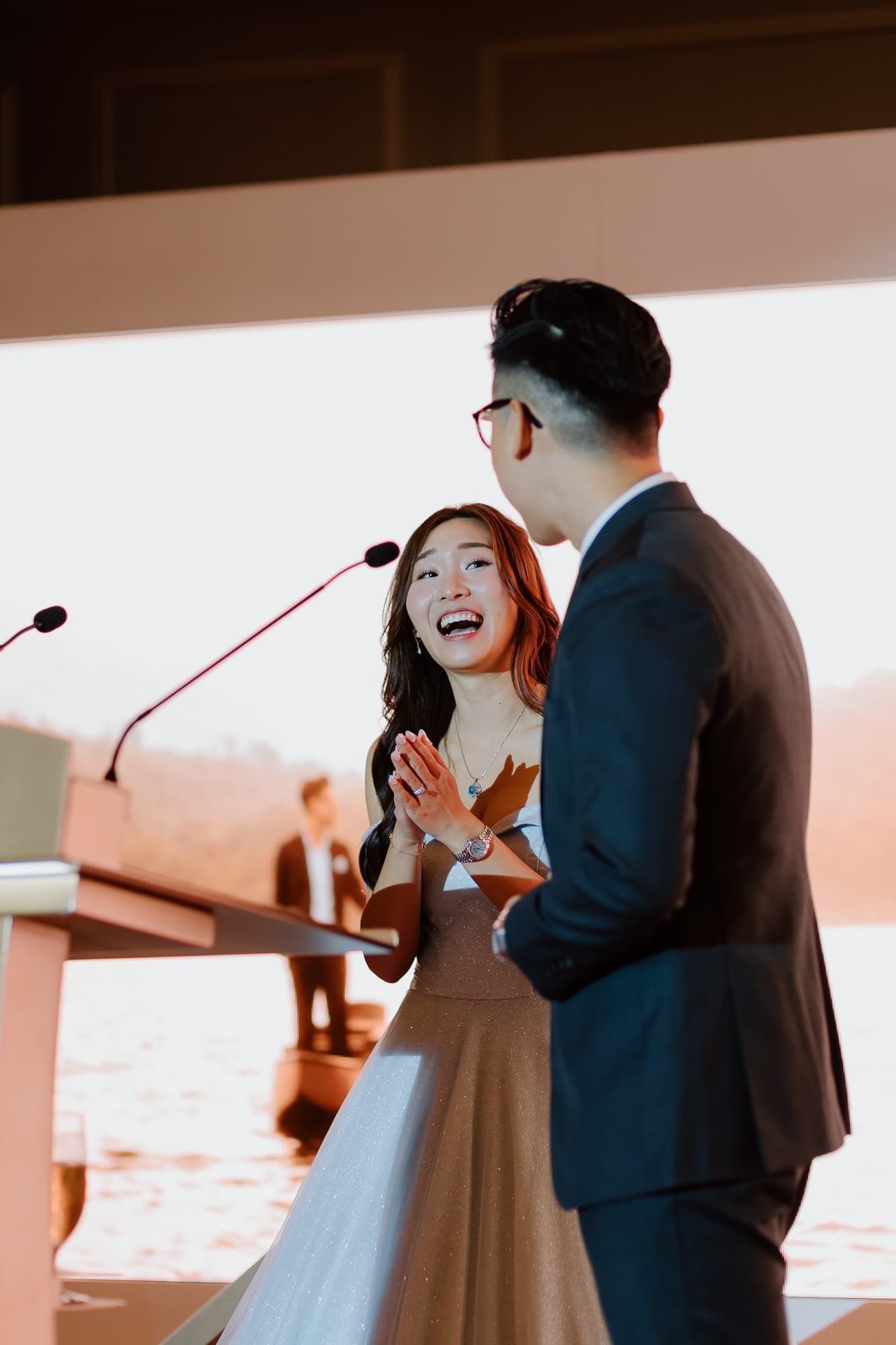 Emotional wedding ceremony moment captured in warm sunlit venue.