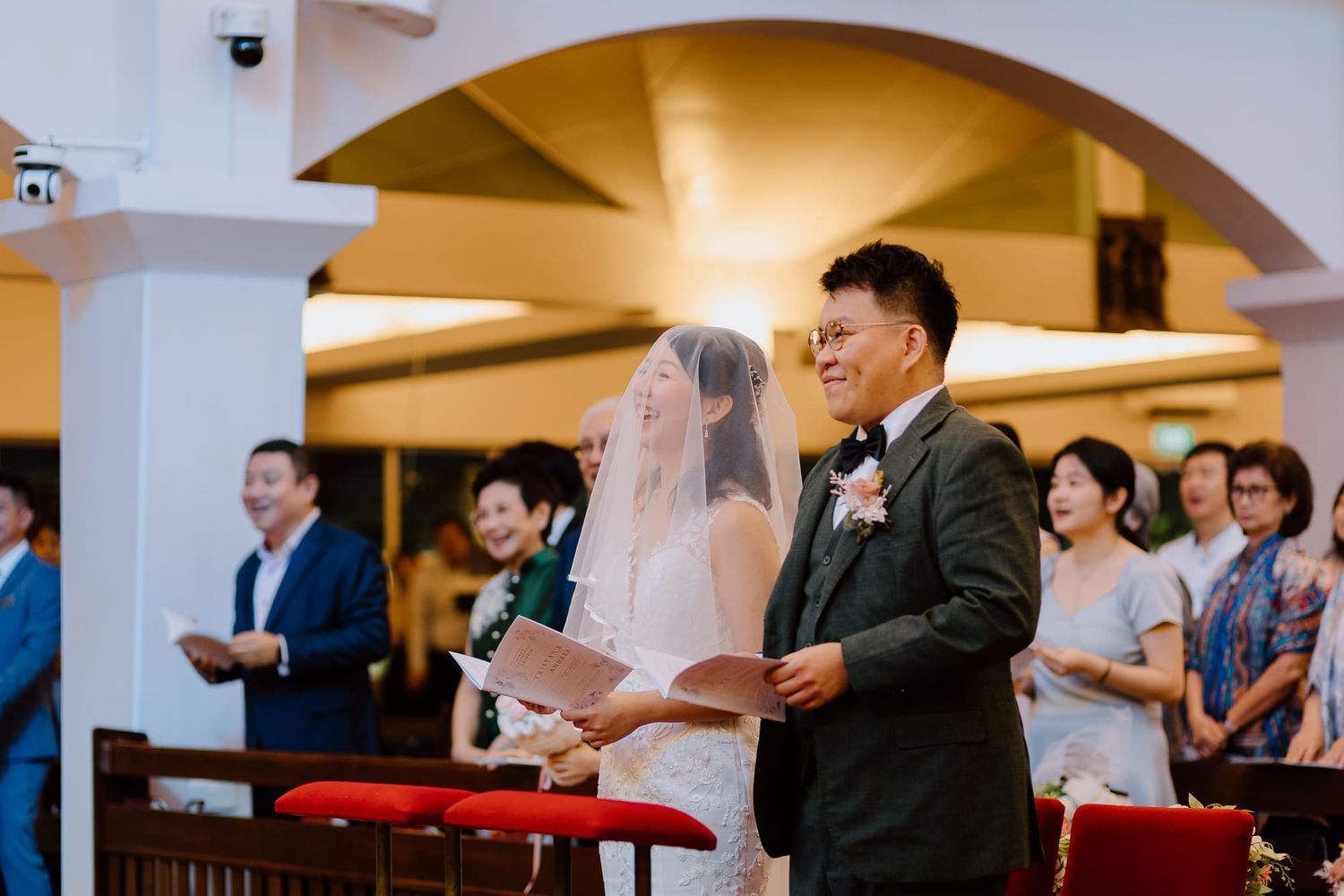 People standing in rows inside a church during a ceremony or service.