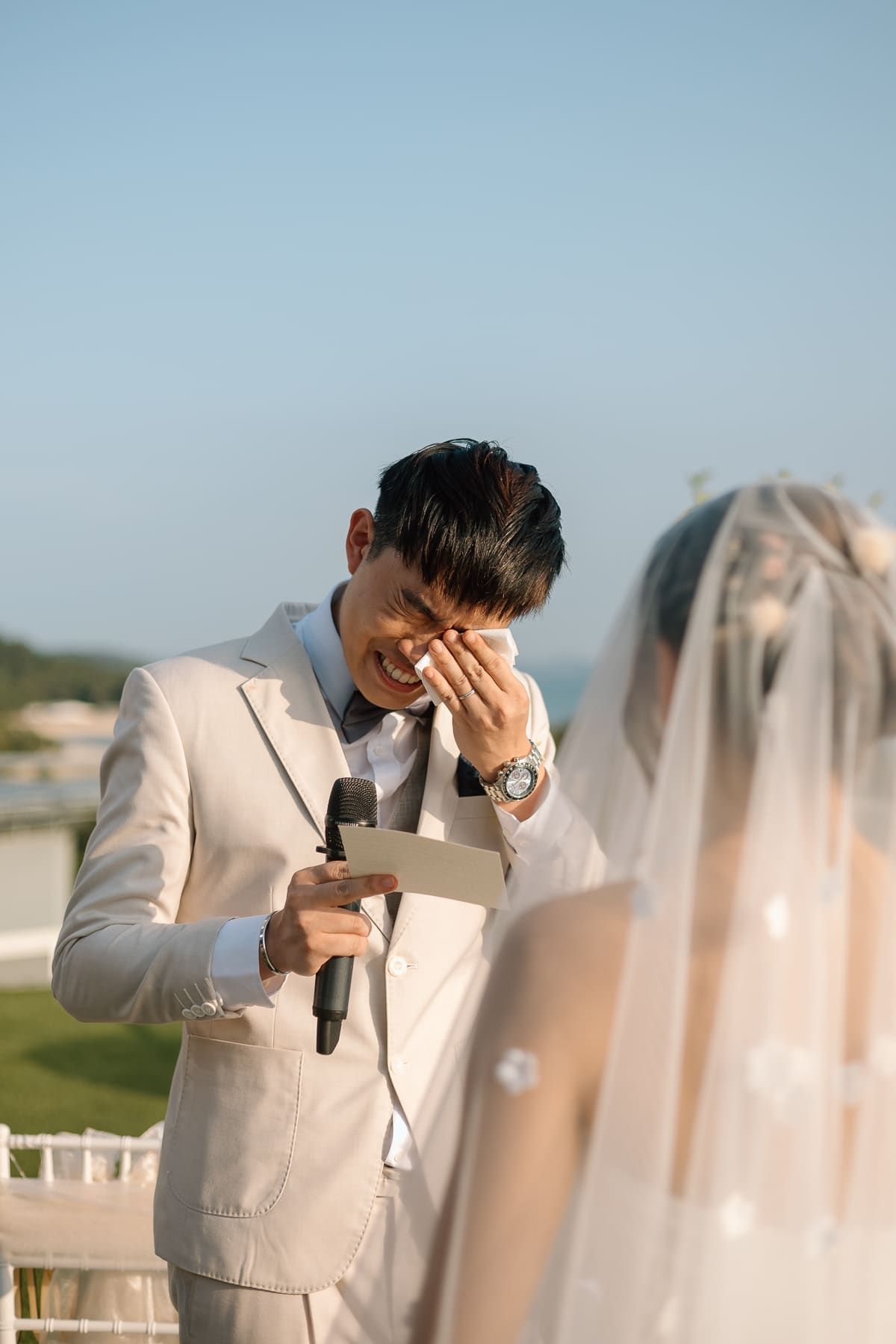 An emotional moment during the wedding vows at an outdoor ceremony.