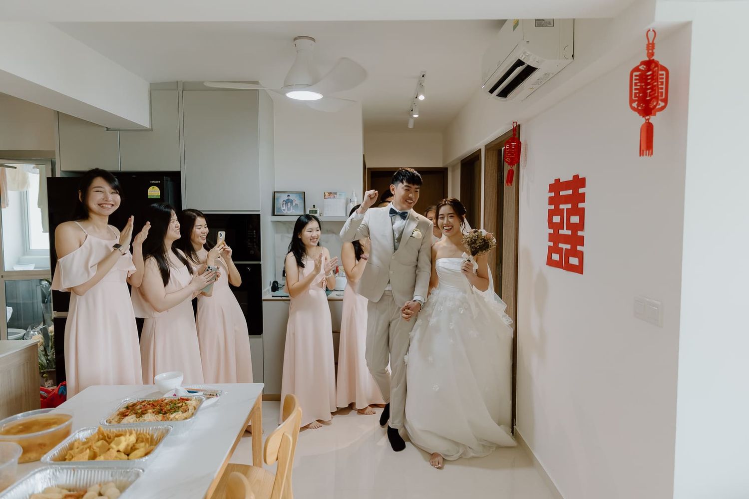 Wedding celebration in modern interior with pink dresses and Chinese decorations.