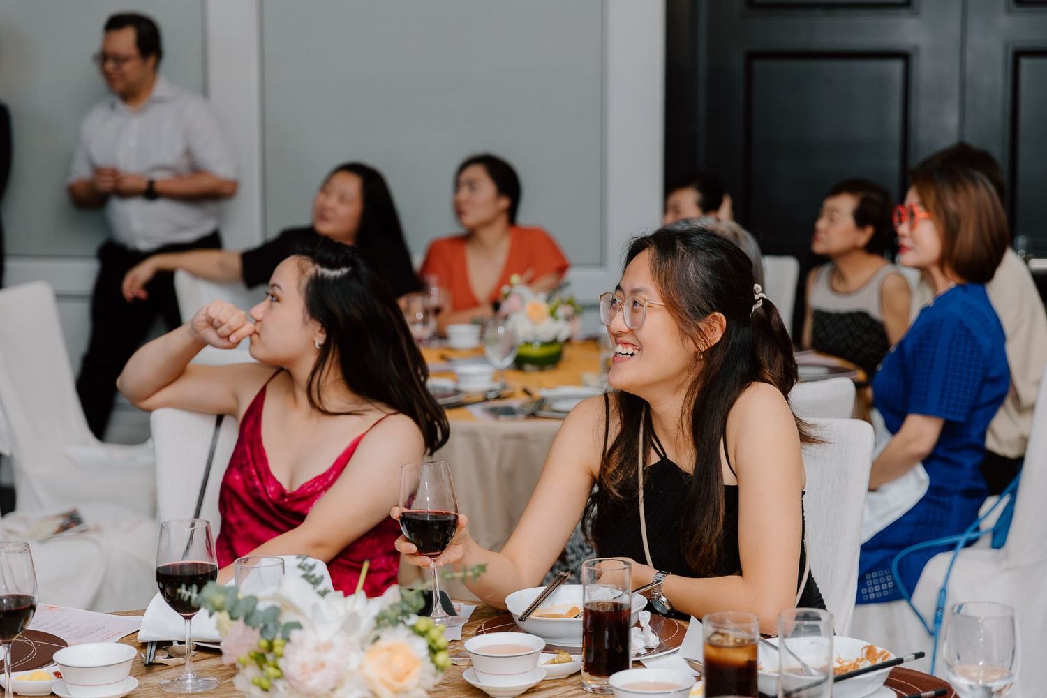 Wedding guests enjoying dinner and conversation at elegant reception tables.