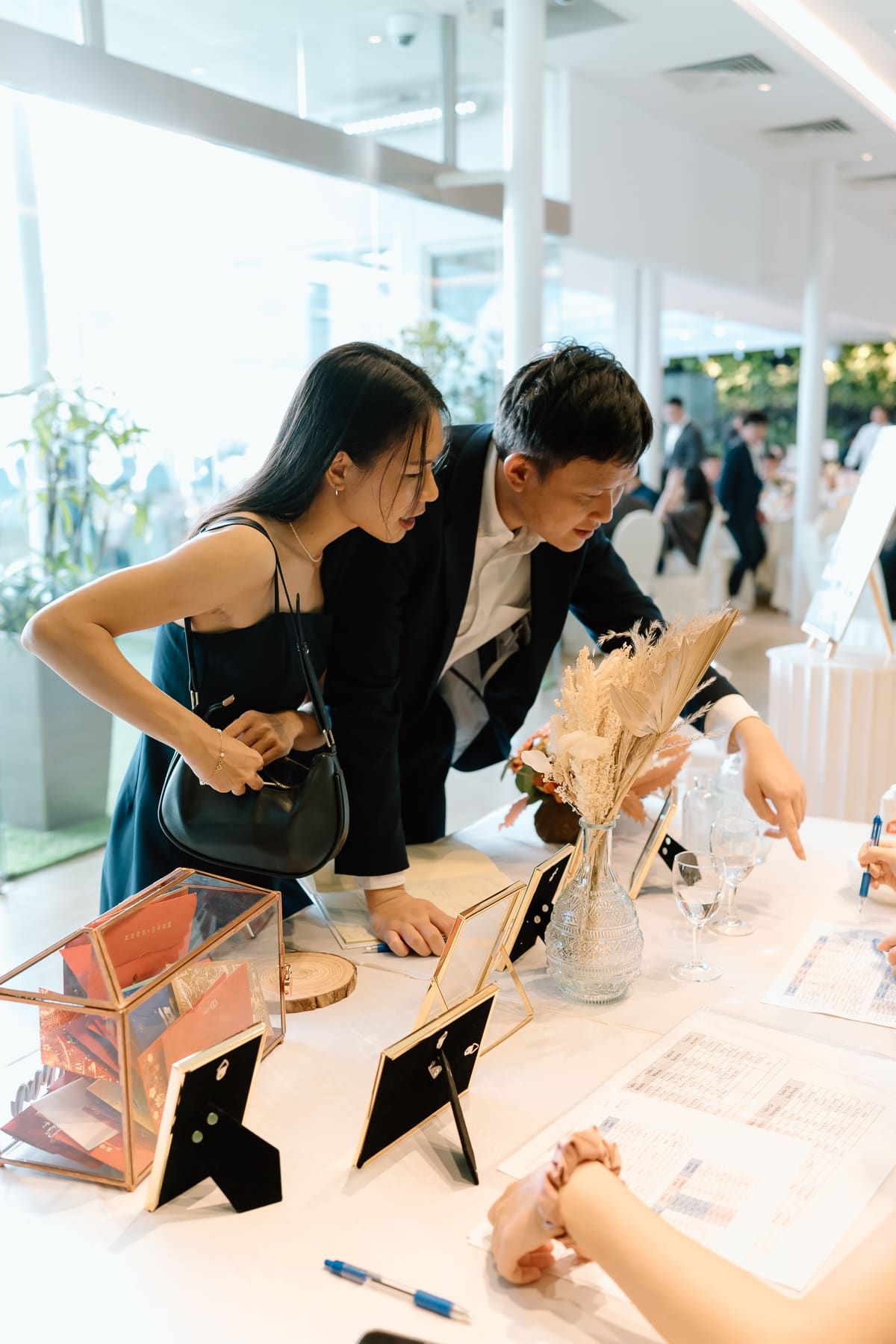 Wedding guests signing the guest book at a modern reception venue.