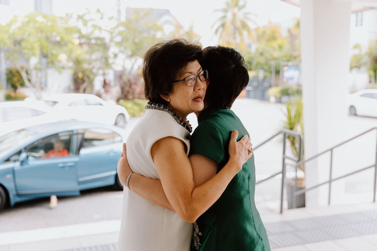 Wedding guests sharing emotional embraces during outdoor celebration.