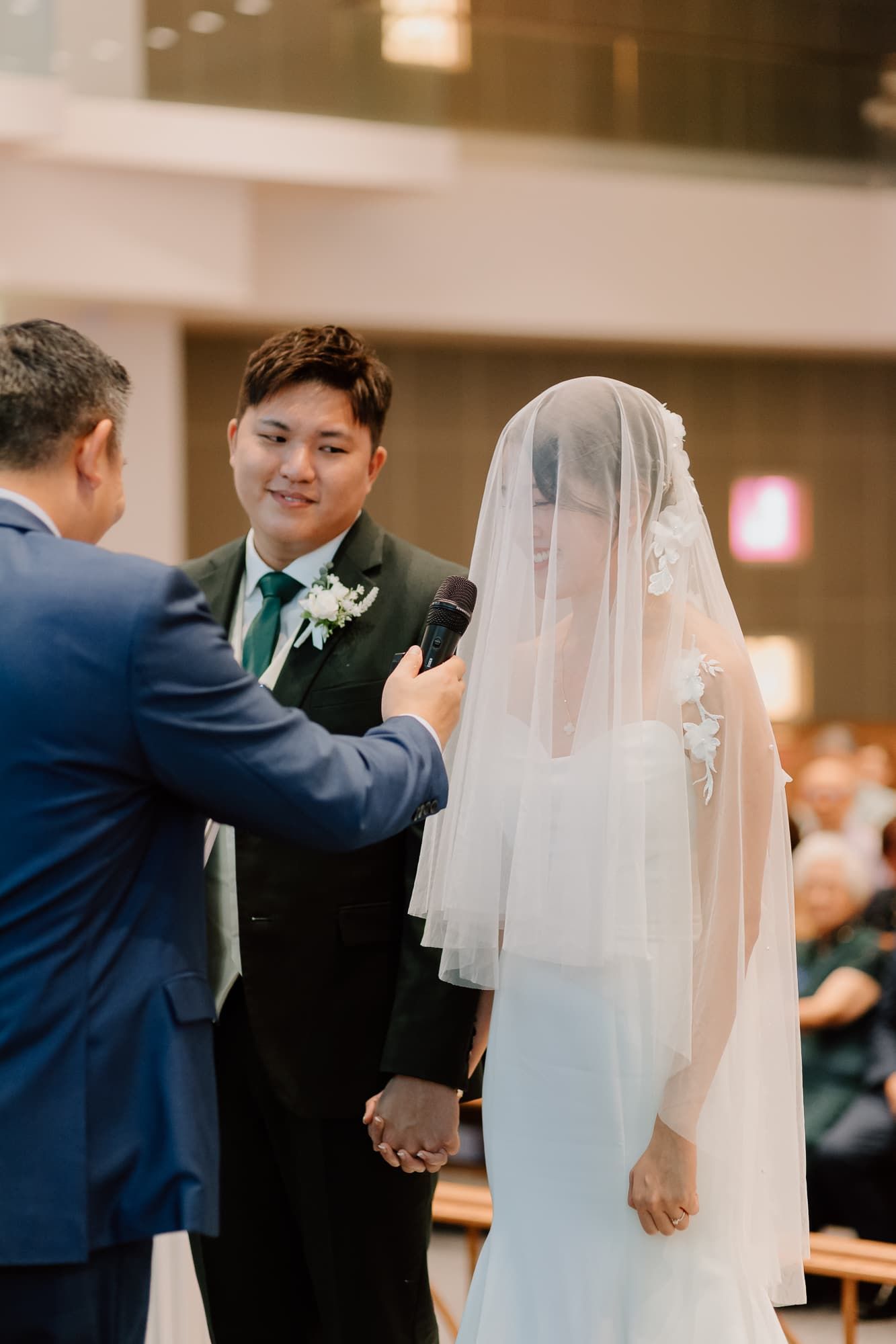 Wedding officiant addresses couple during church ceremony.
