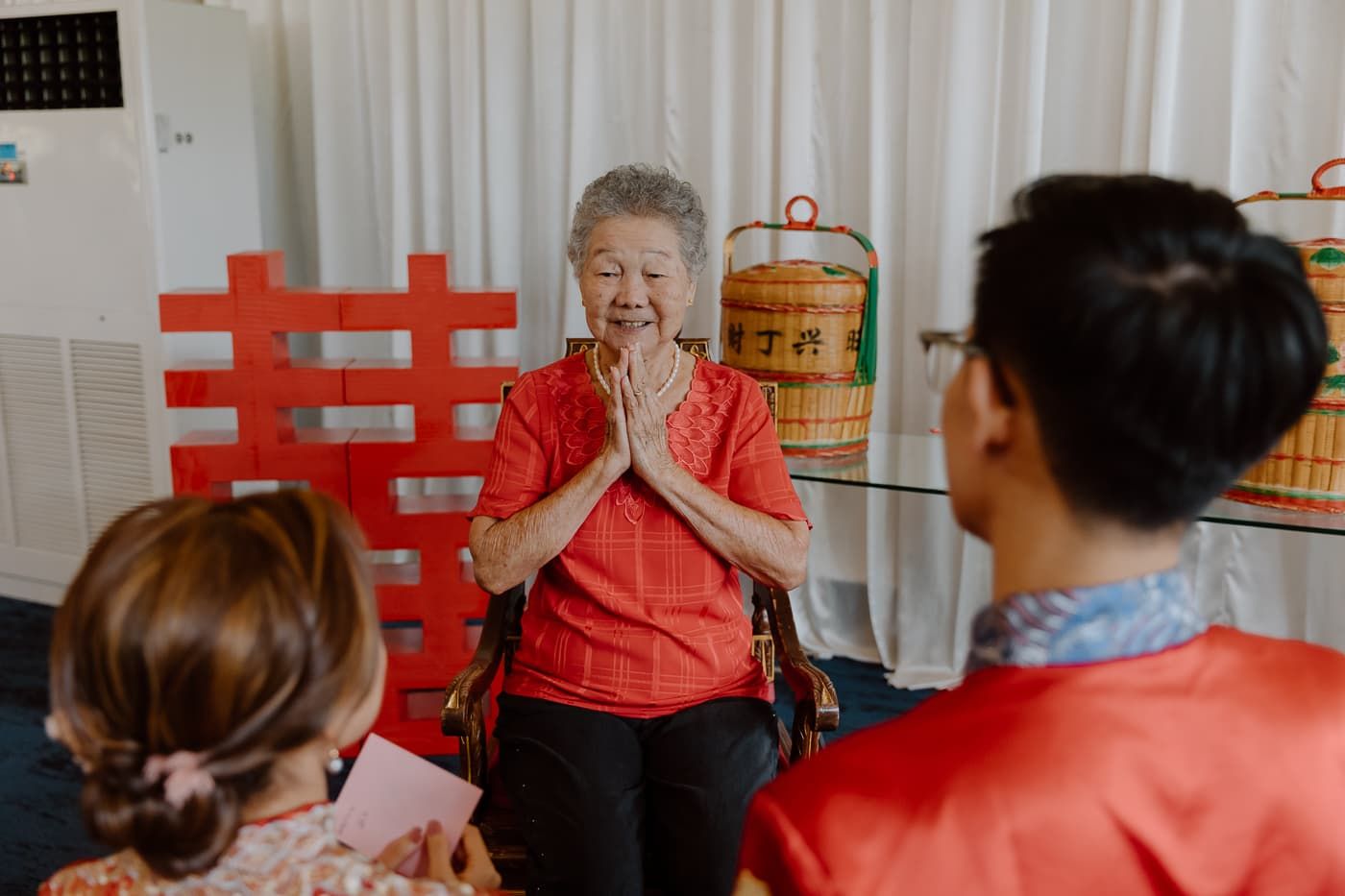 Wedding celebration with traditional Chinese decorations and red double happiness symbols.