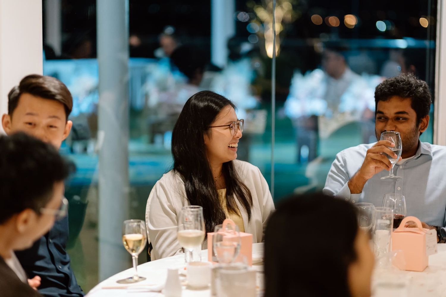 Evening wedding reception with guests seated at elegant dining tables.