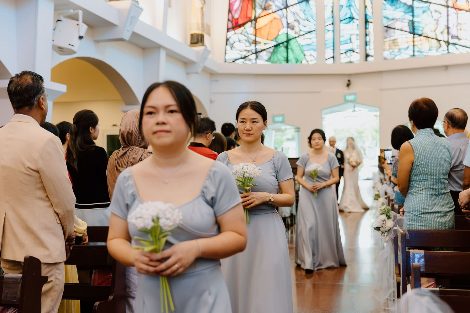 People gathered in a church-like venue with stained glass windows and bright interior lighting.