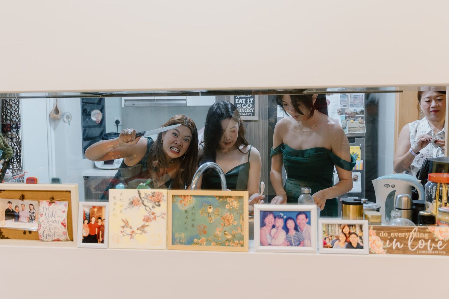 Group enjoying a celebratory moment in a kitchen with photo memories displayed on the wall.