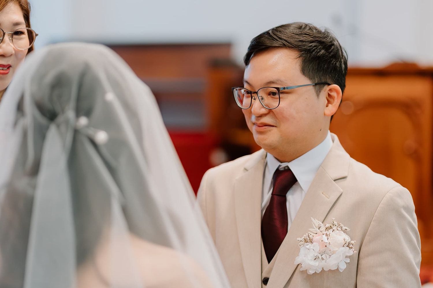 A bride in a white wedding gown speaks into a microphone during the ceremony.