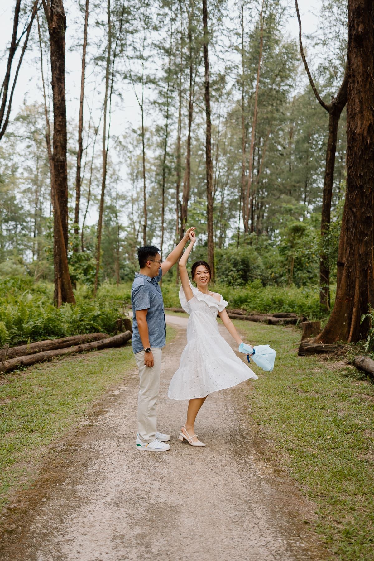 Dancing together on a forest trail surrounded by tall pine trees.