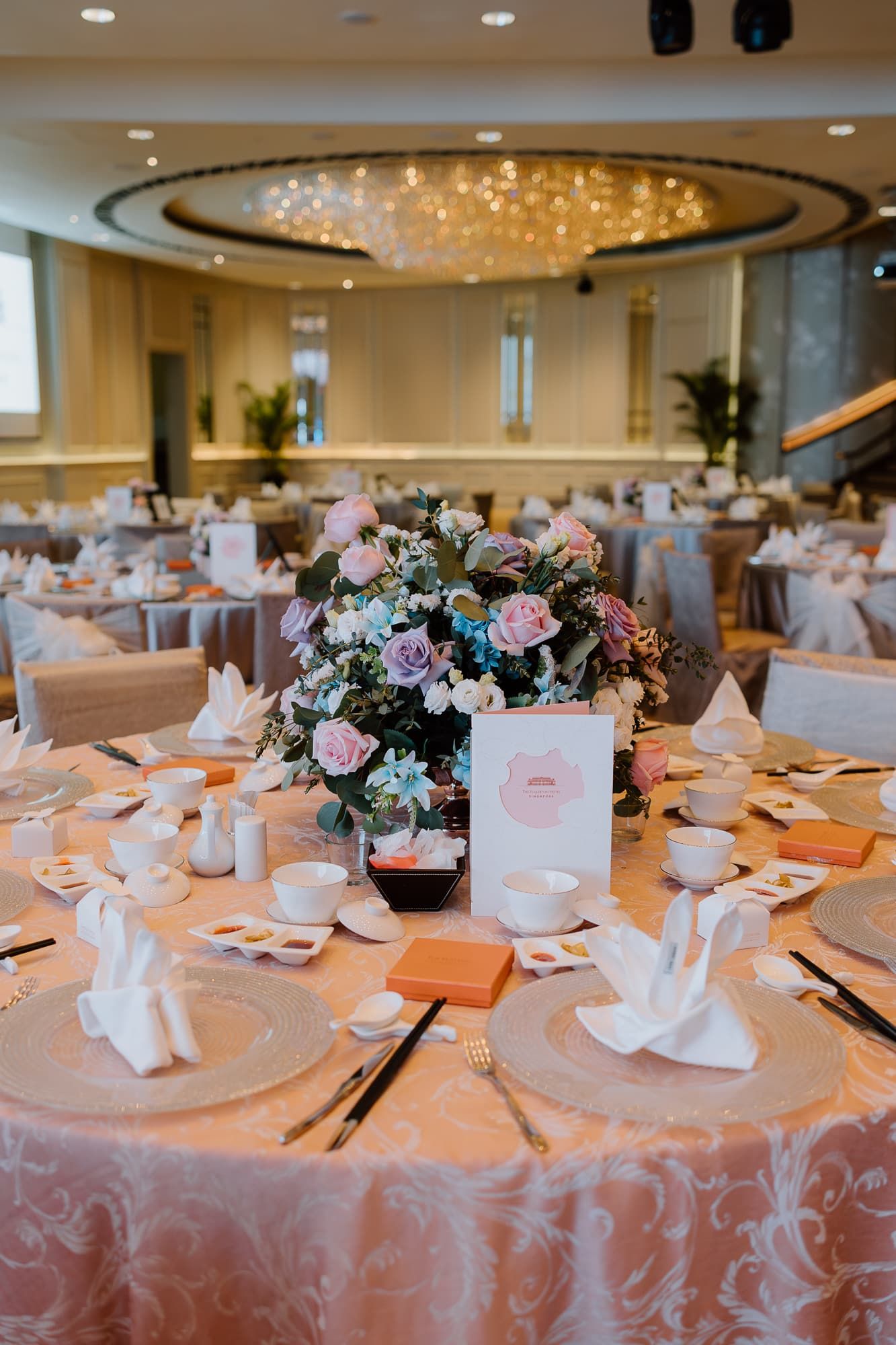 Wedding reception tables decorated with pink and blue floral centerpieces and white linens.