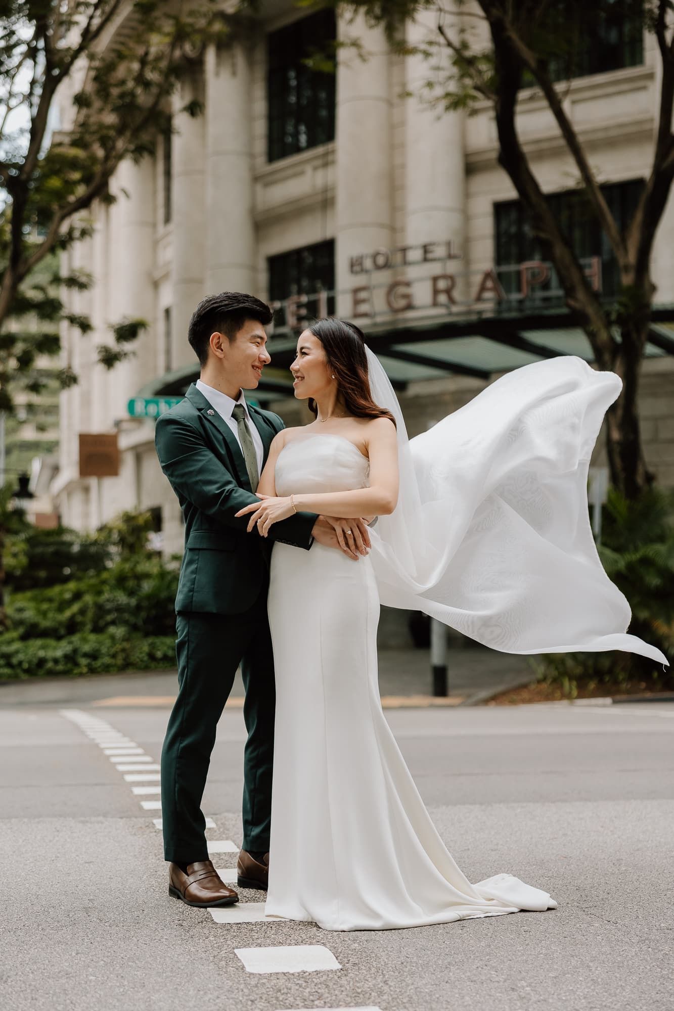 Elegant wedding photos with the bride's dress flowing dramatically against an urban backdrop.