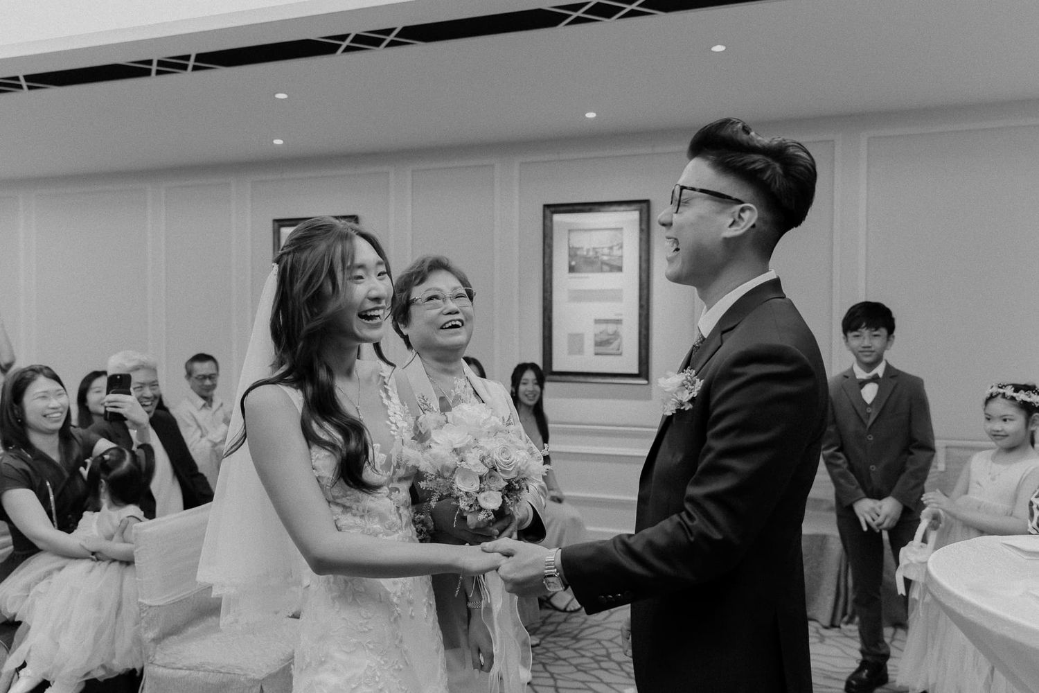 Black and white photograph of a joyful wedding ceremony moment.