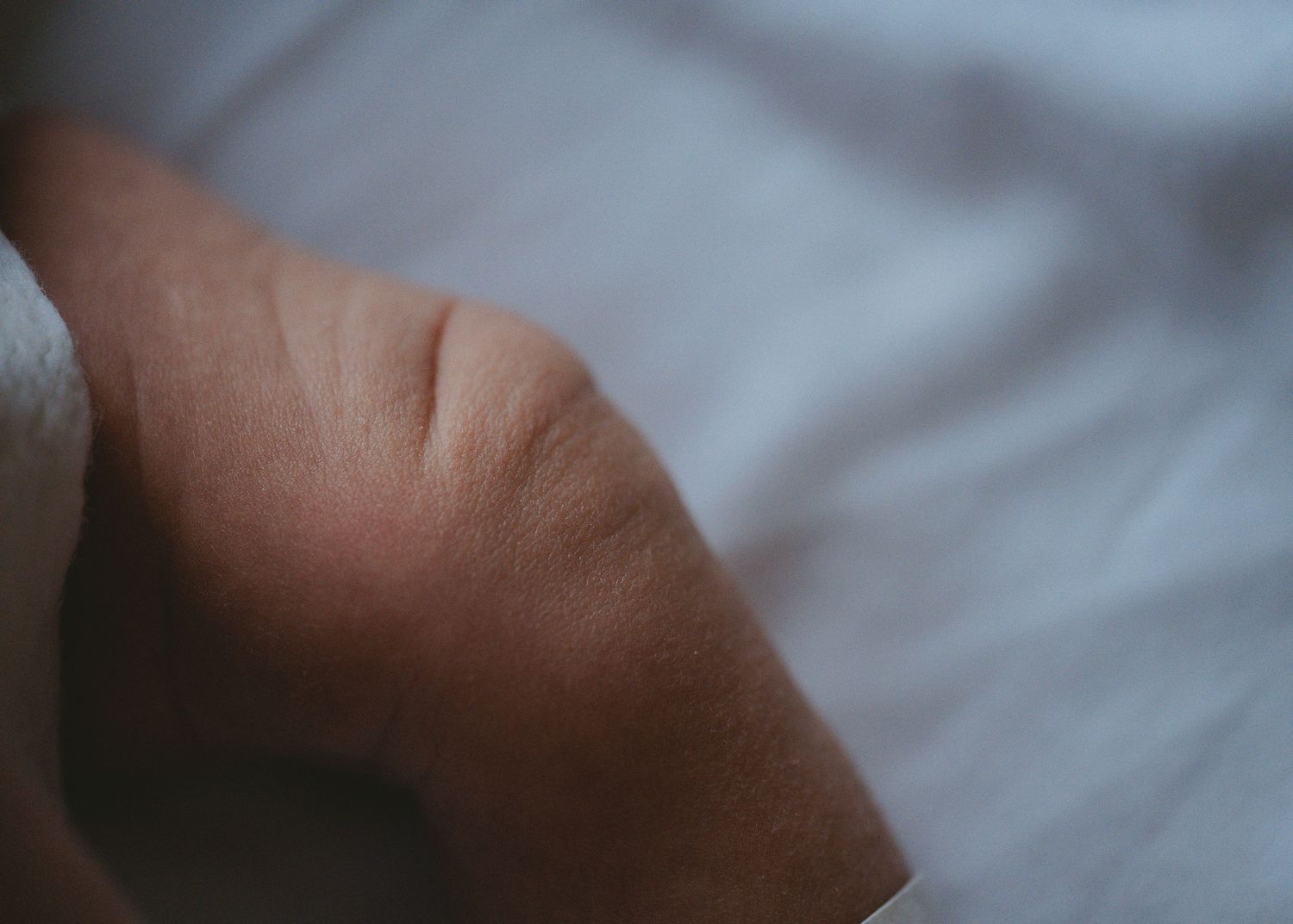 Close-up view of a newborn baby's soft skin in gentle lighting.