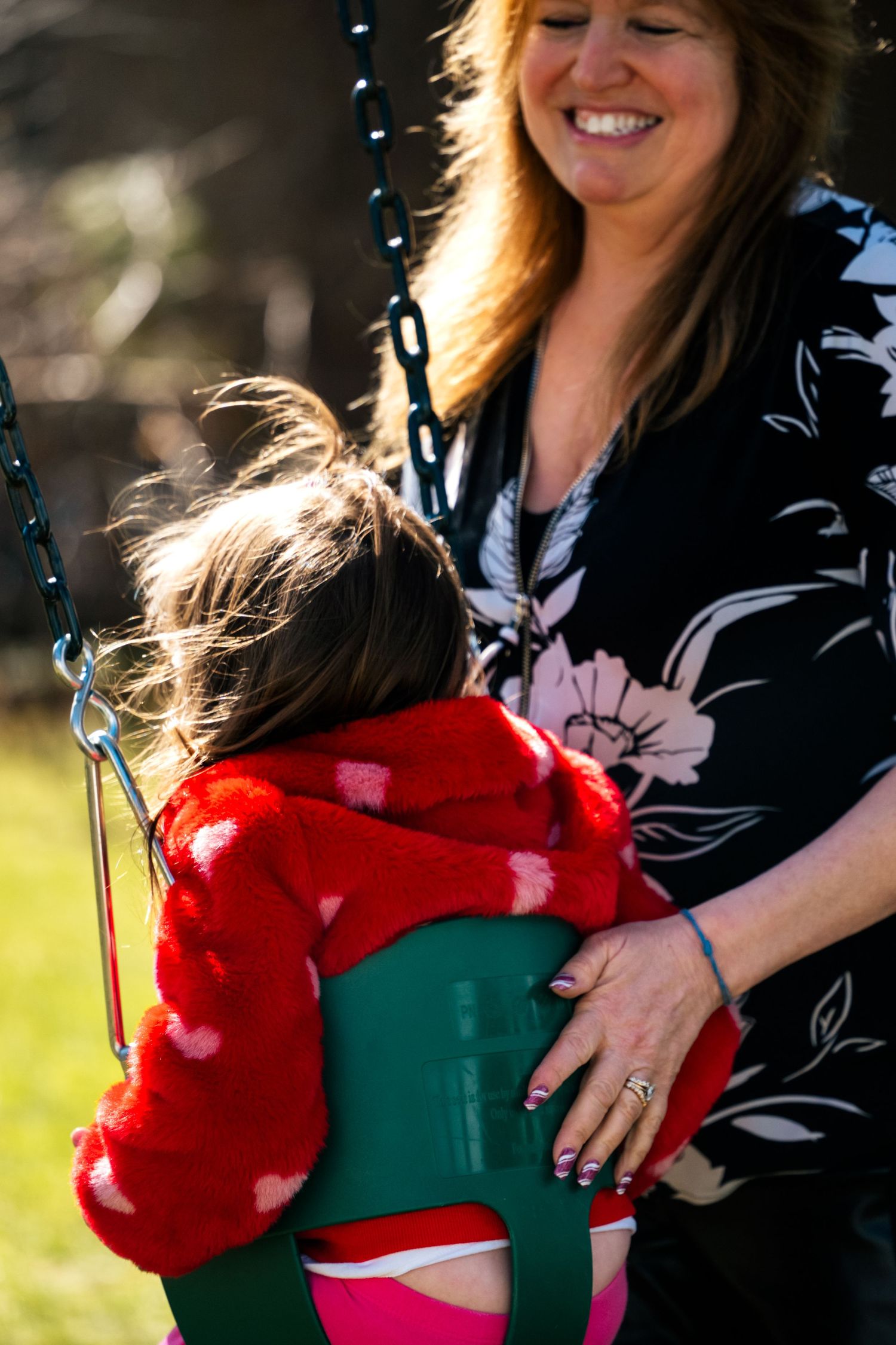 Birthday girl on the swings with grandmother pushing