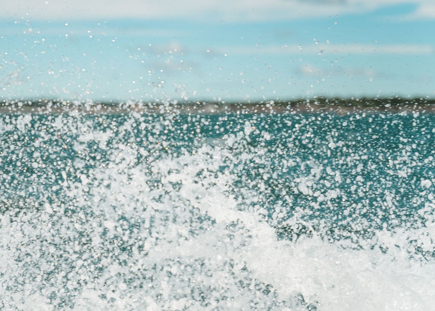 Ocean waves creating dramatic splashes against turquoise blue water backdrop.