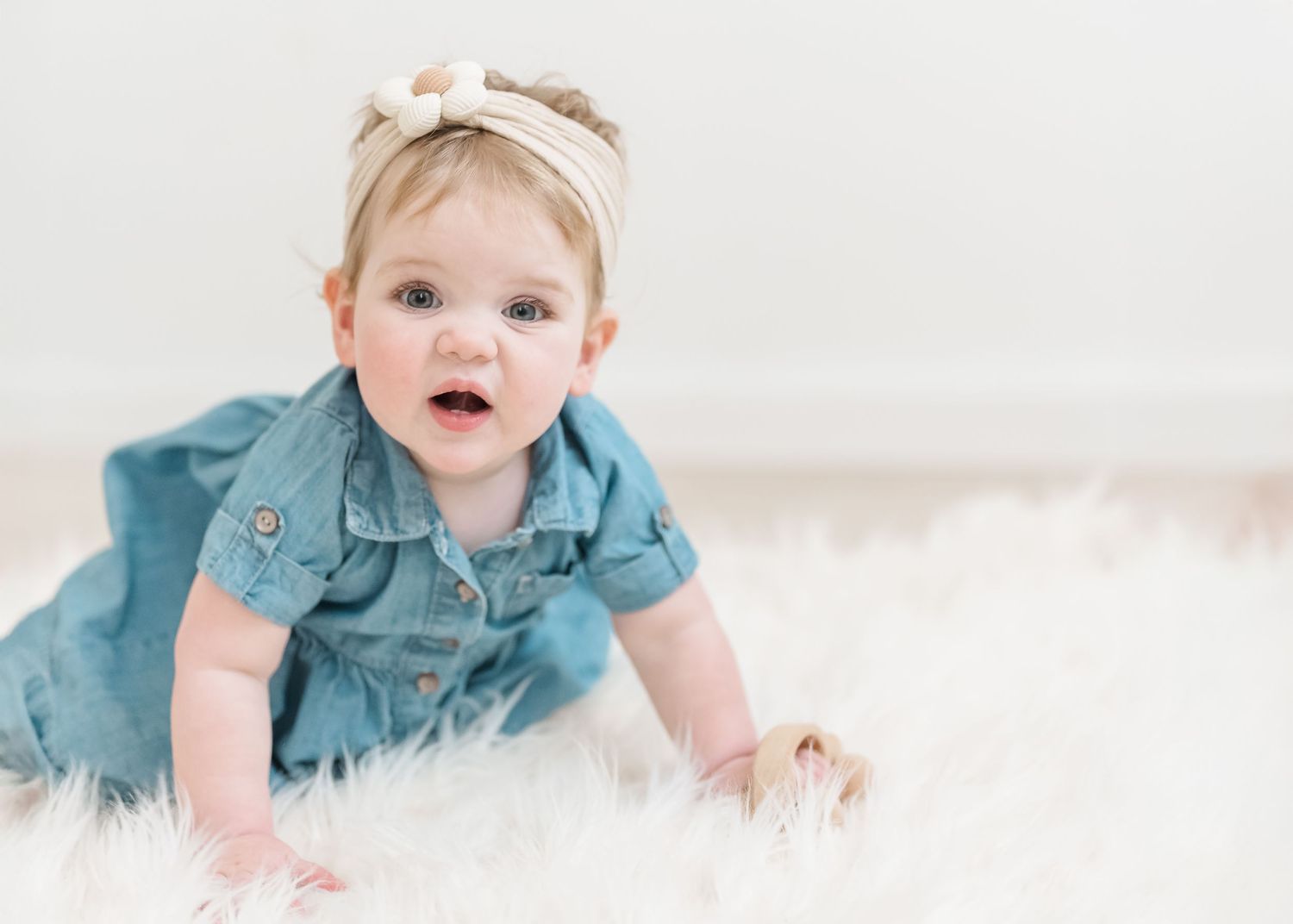 Baby in teal blue outfit crawls and plays on white background in progressive action shots.